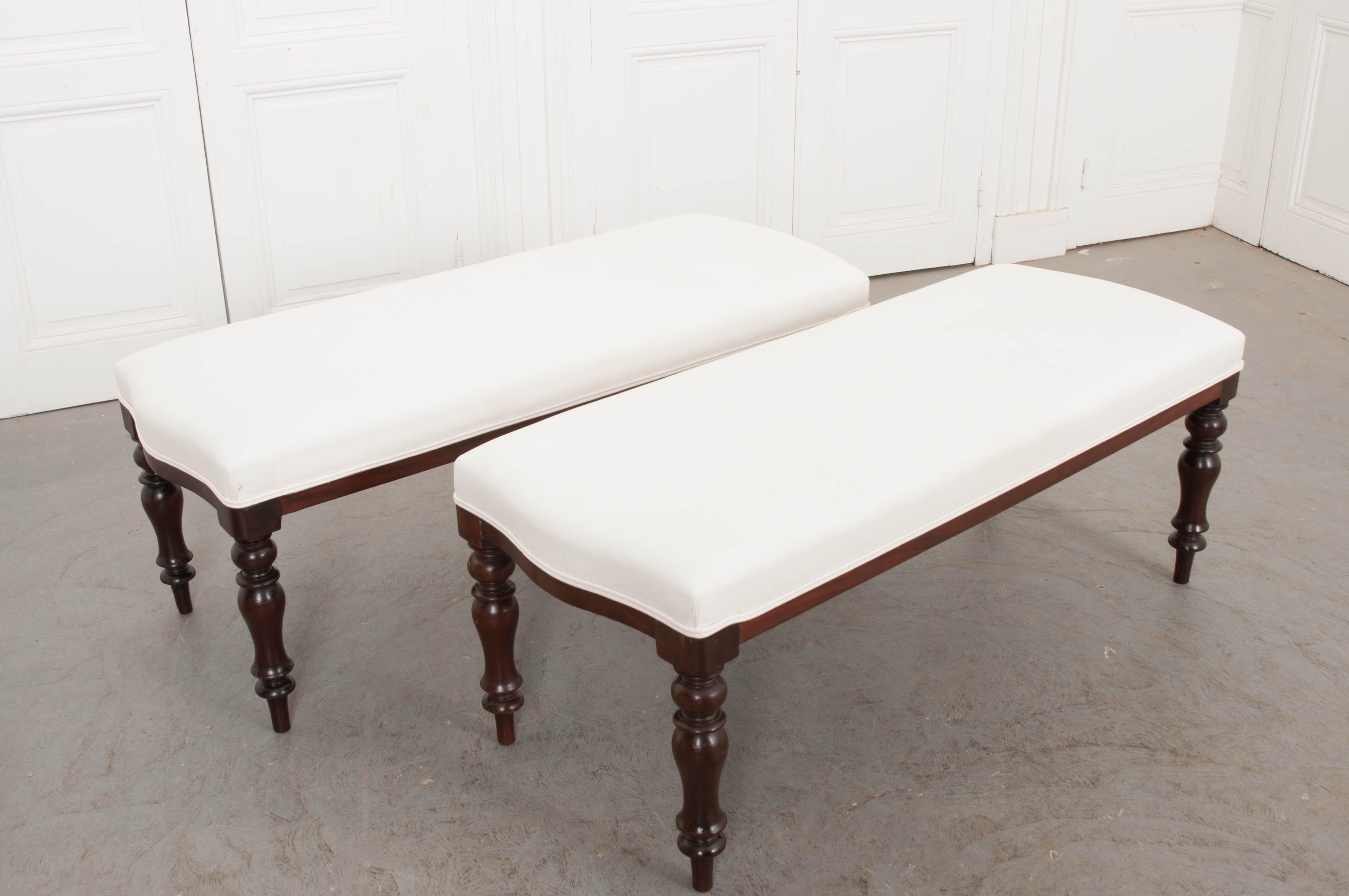 This fantastic pair of George III mahogany benches, circa 1820, is from England and features serpentine sides and finely turned legs. Newly upholstered in a white muslin with double-welt cording. Available individually for $1450.00.