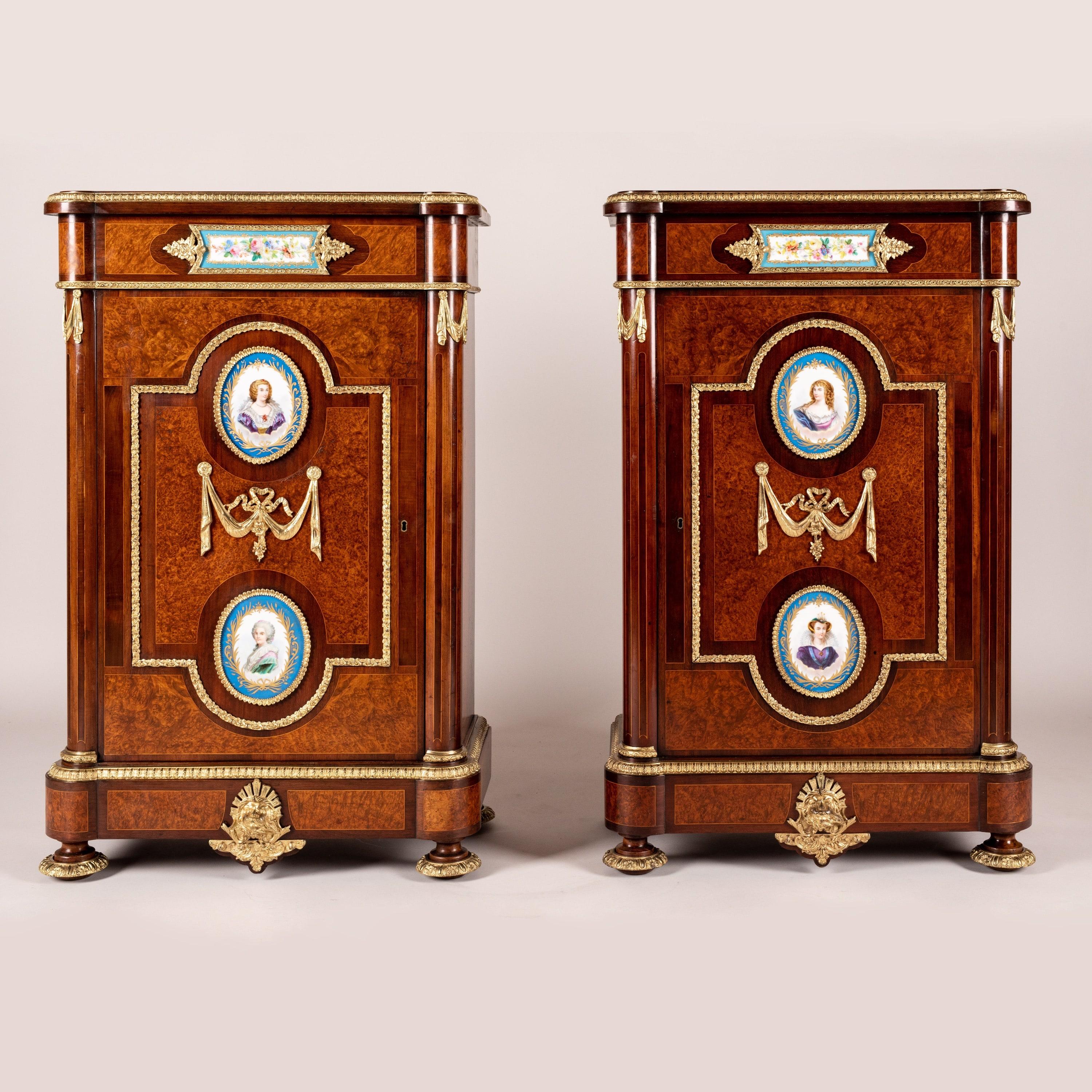 A Pair of Porcelain-Mounted
Pier Cabinets

The English-made side cabinets with fixed-shelved interior constructed from rare amboyna with purpleheart crossbanding and boxwood stringing; each supported on ormolu-mounted oblate feet, the rounded