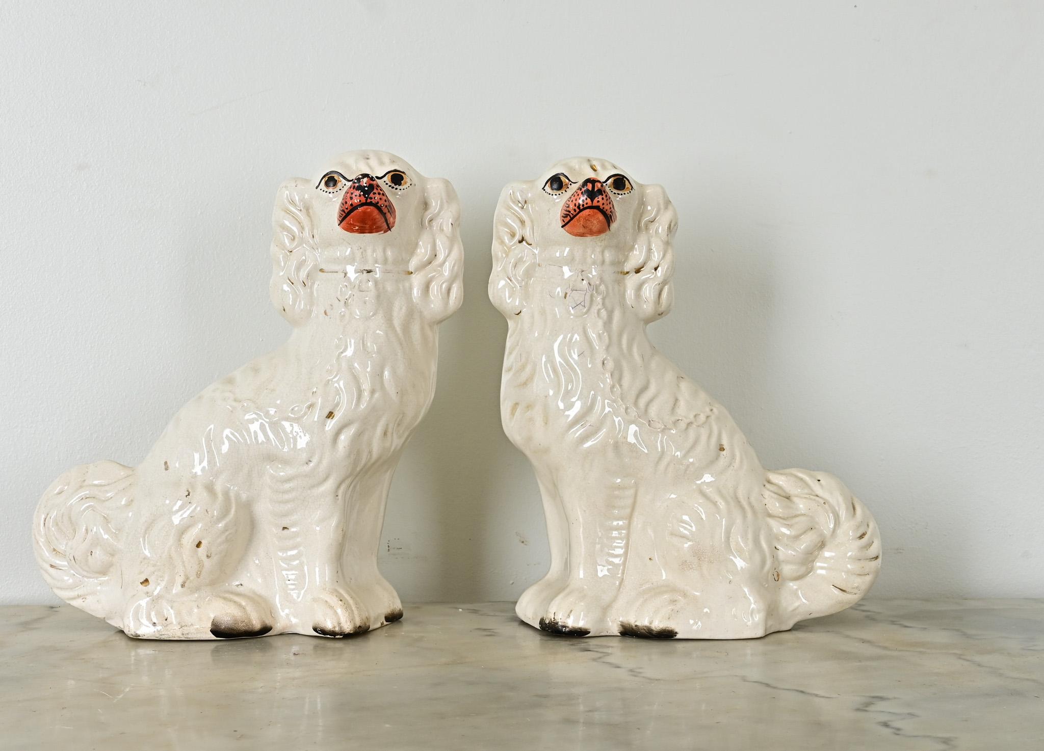 A darling pair of white Staffordshire spaniels from England, circa 1880. Patinated gold gilt accents within their fur and collar are a wonderful contrast to their glazed white bodies. Make sure to view the detailed images to get a closer look at
