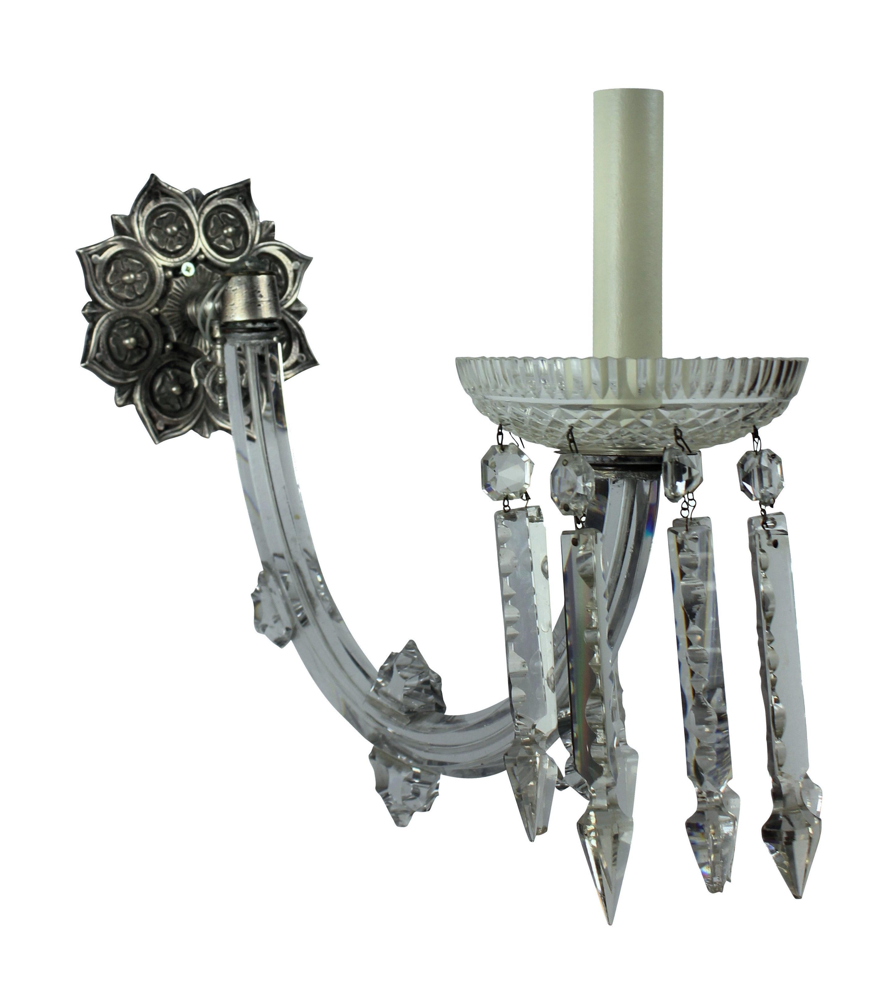 A pair English single arm wall sconces of fine quality, with large up-swept hand cut glass arms with decorative glass finials, finely cut dishes hung with prisms. The metal work of silvered bronze.