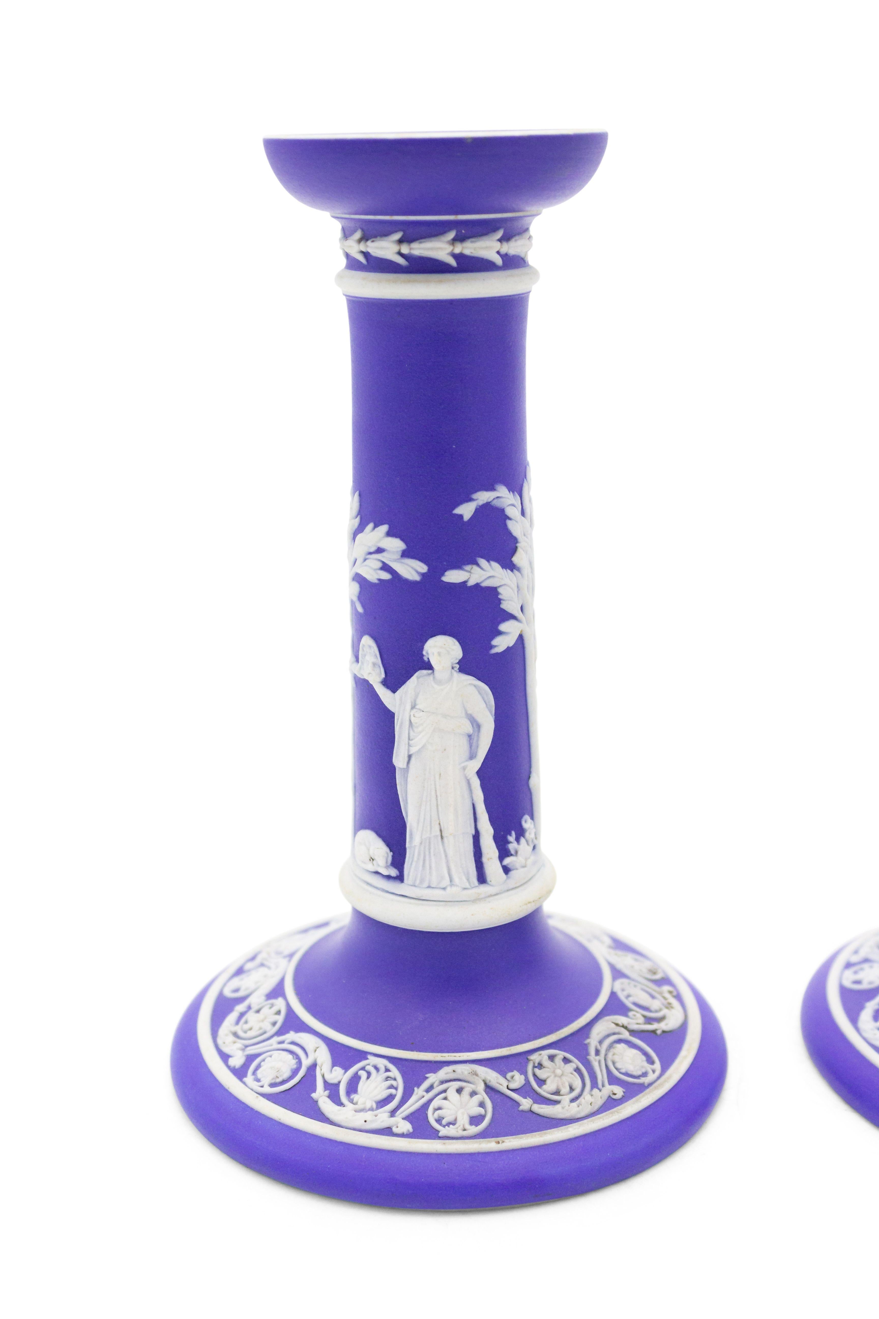 Pair of English Adam-style (19/20th Century) blue and white Wedgwood porcelain candlesticks with classical figures and scroll decorated base (Priced as pair).
    