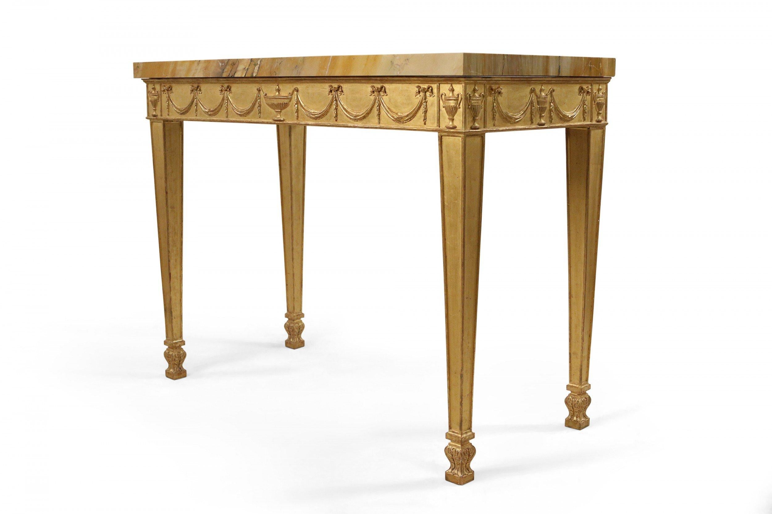 Pair of English Adam neoclassic style 19th century carved giltwood console tables with carved urn and swag relief design on apron supported on square tapered legs over Sienna yellow marble tops.