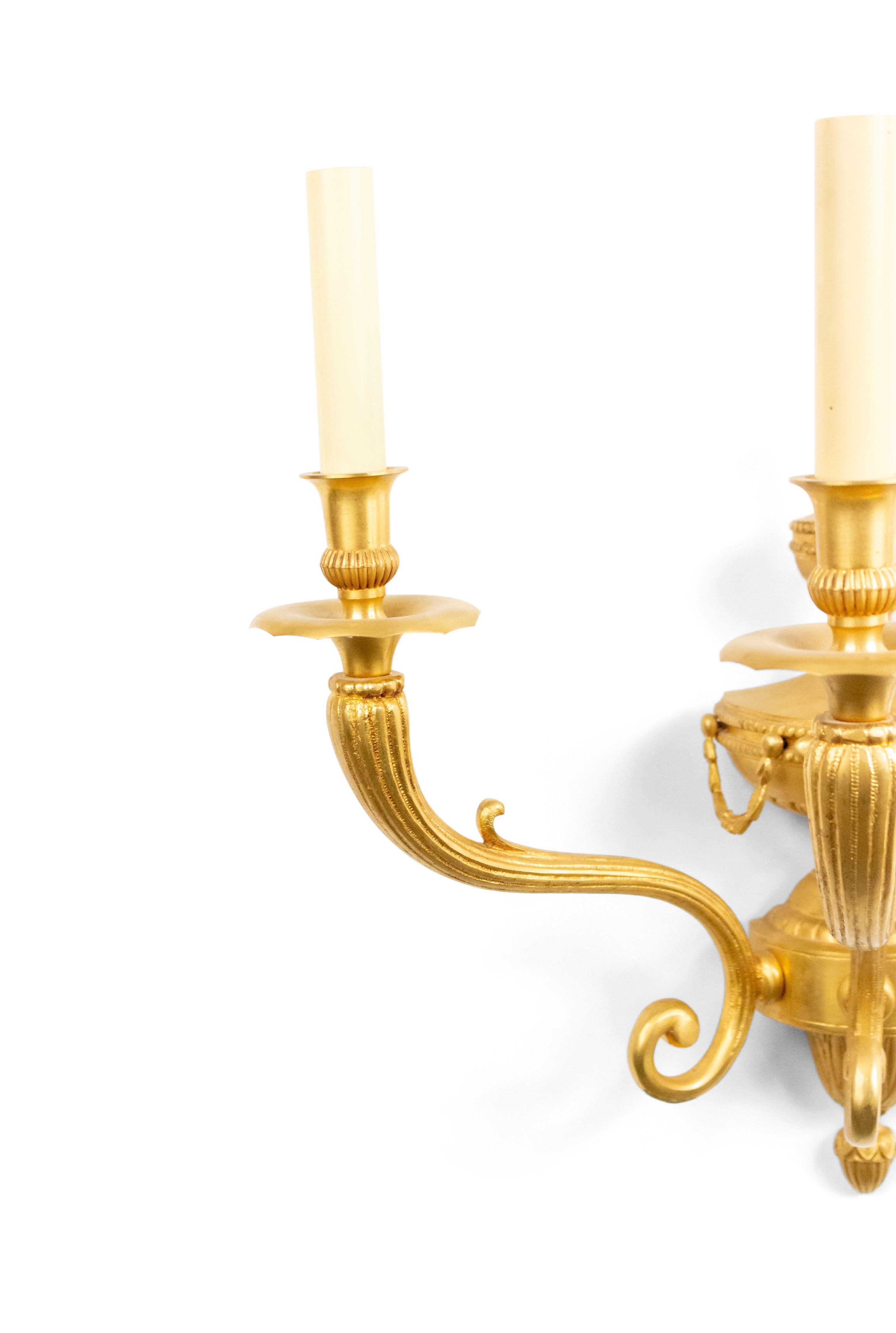 Pair of English Adam-style (20th century) bronze dore wall sconces with three fluted scroll arms and urn and festoon design centers. (priced as pair).
      