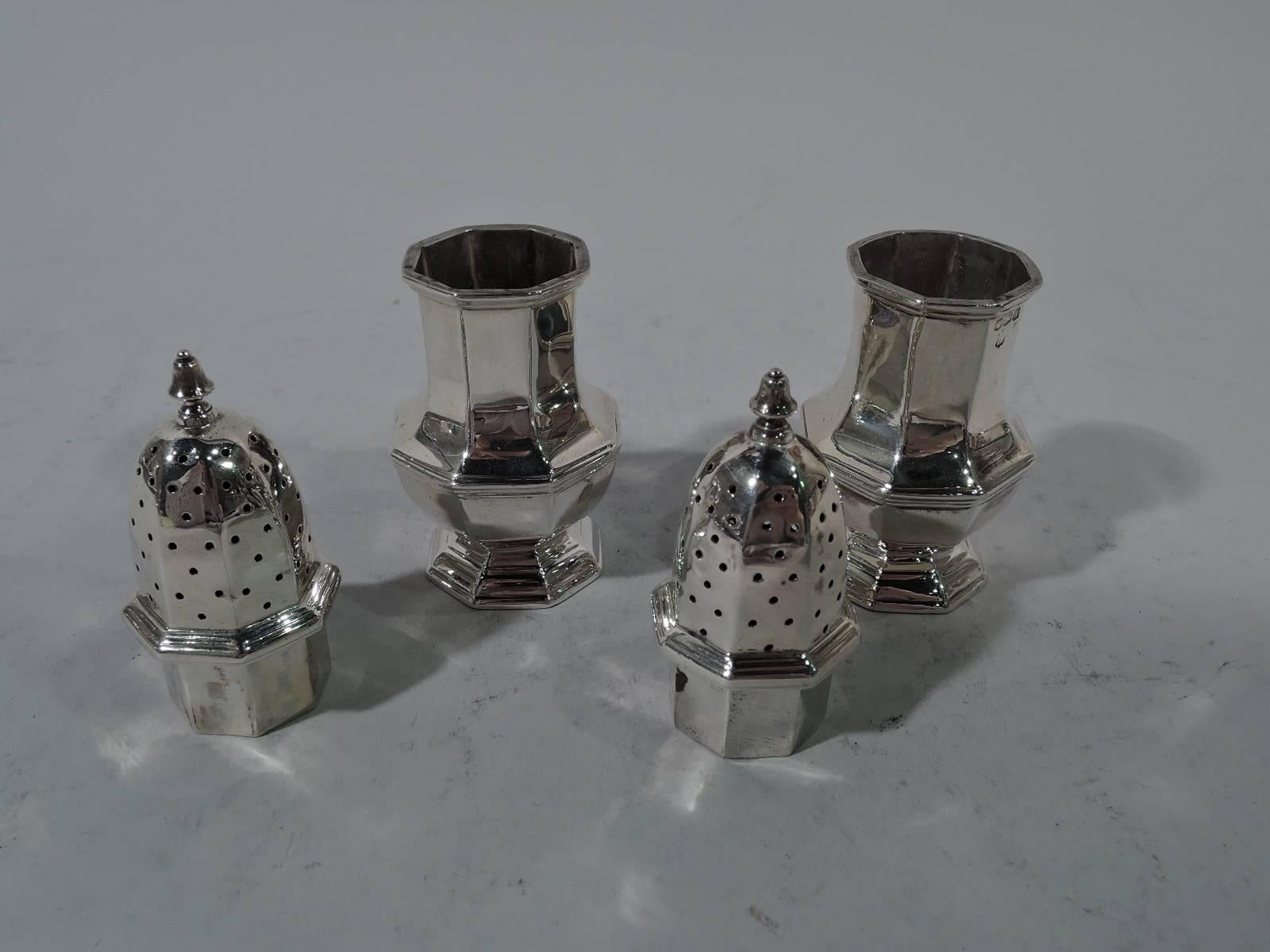 Pair of Art Deco sterling silver salt and pepper shakers. Made by Thomas Bradbury in Sheffield. Each: Faceted baluster and raised foot. Pierced domed cover and bell finial. A nice pair that combines traditional form and geometric innovation.