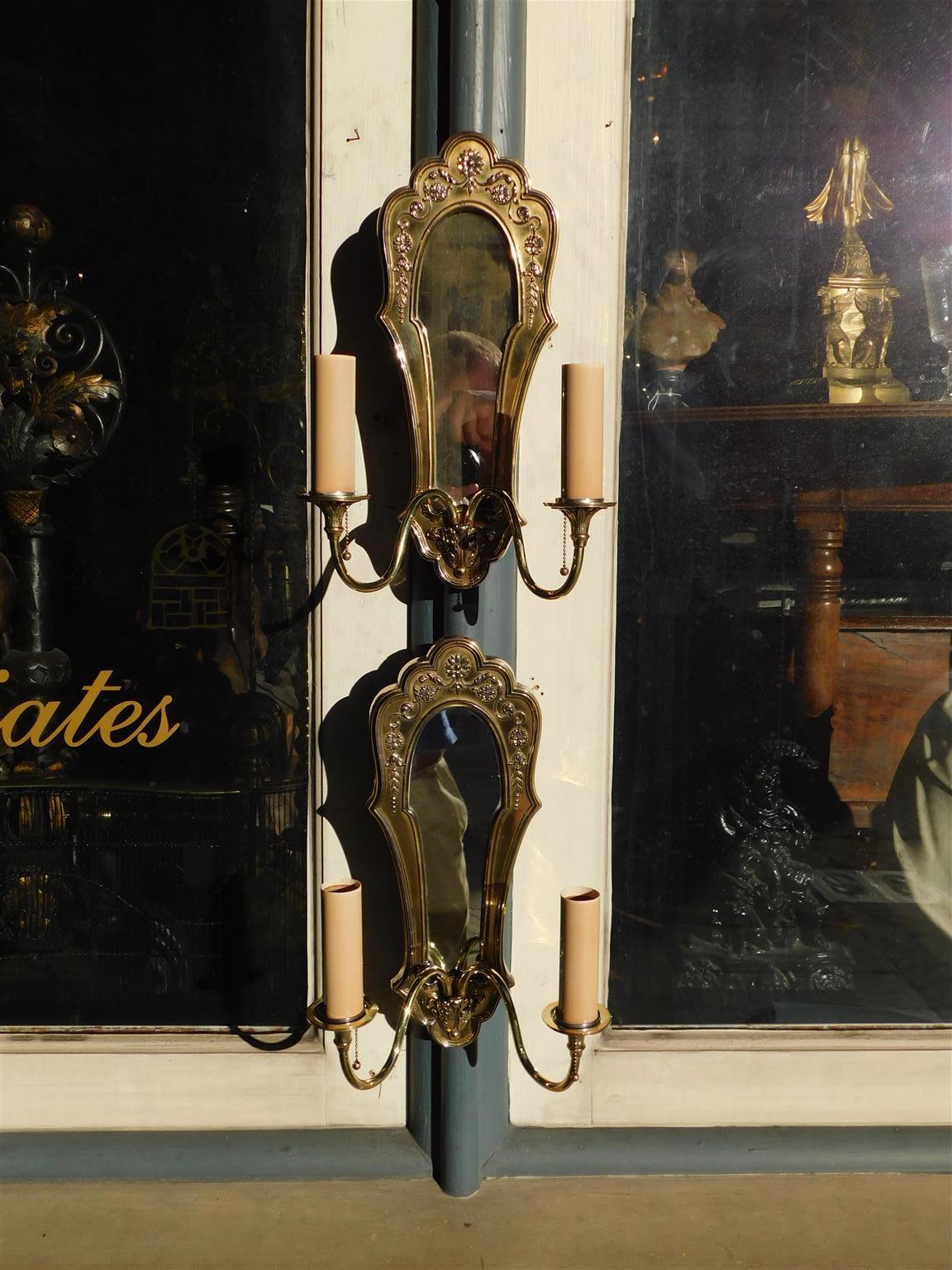 Ein Paar englische Messing-Lüster mit zwei verschnörkelten Armen, Medaillons, abgestuften Glockenblumen und Akanthusmotiv. Ein Paar wurde elektrifiziert und ursprünglich mit Kerzen betrieben. Bei den Wandleuchtern ist das ursprüngliche versilberte