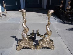 Pair of English Brass Intertwined Dolphin Andirons with Flame Finials. C. 1830