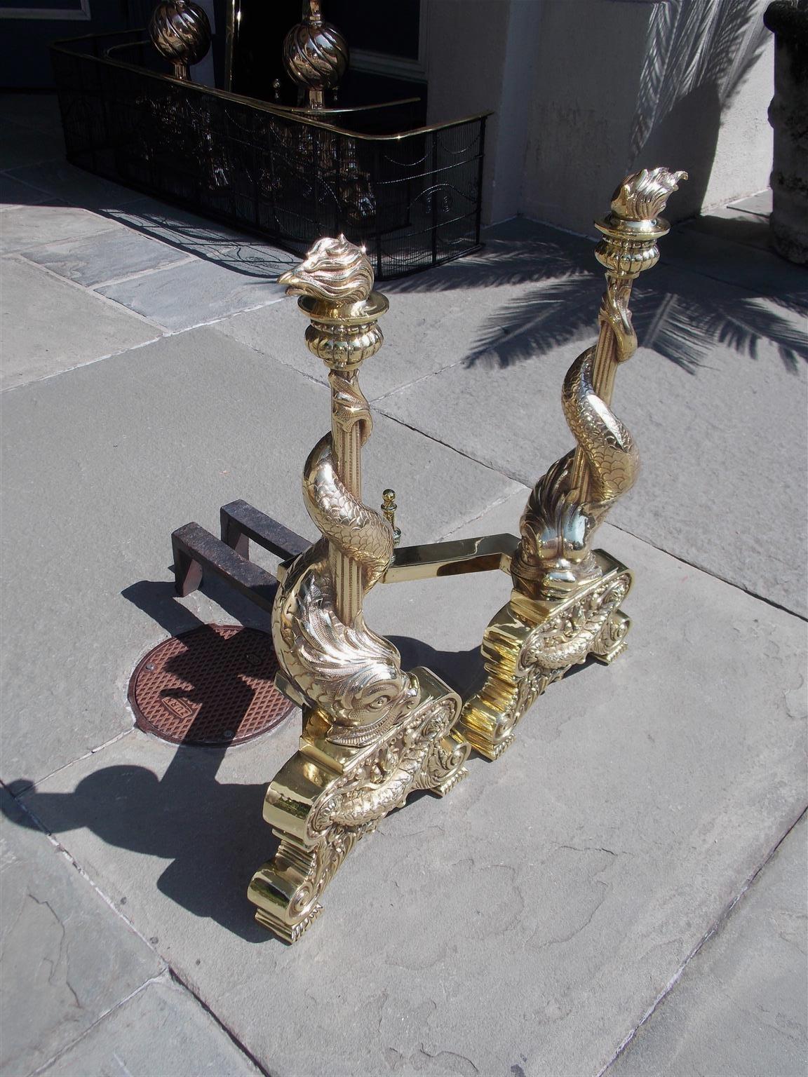 George IV Pair of English Brass Intertwined Dolphin Andirons with Flame Finials. C. 1830 For Sale