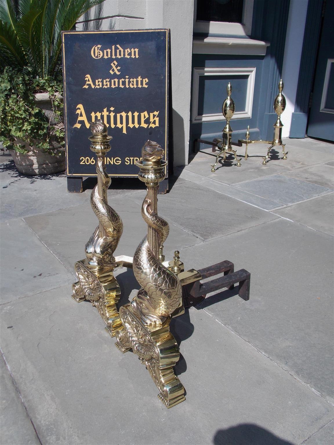 Cast Pair of English Brass Intertwined Dolphin Andirons with Flame Finials. C. 1830 For Sale