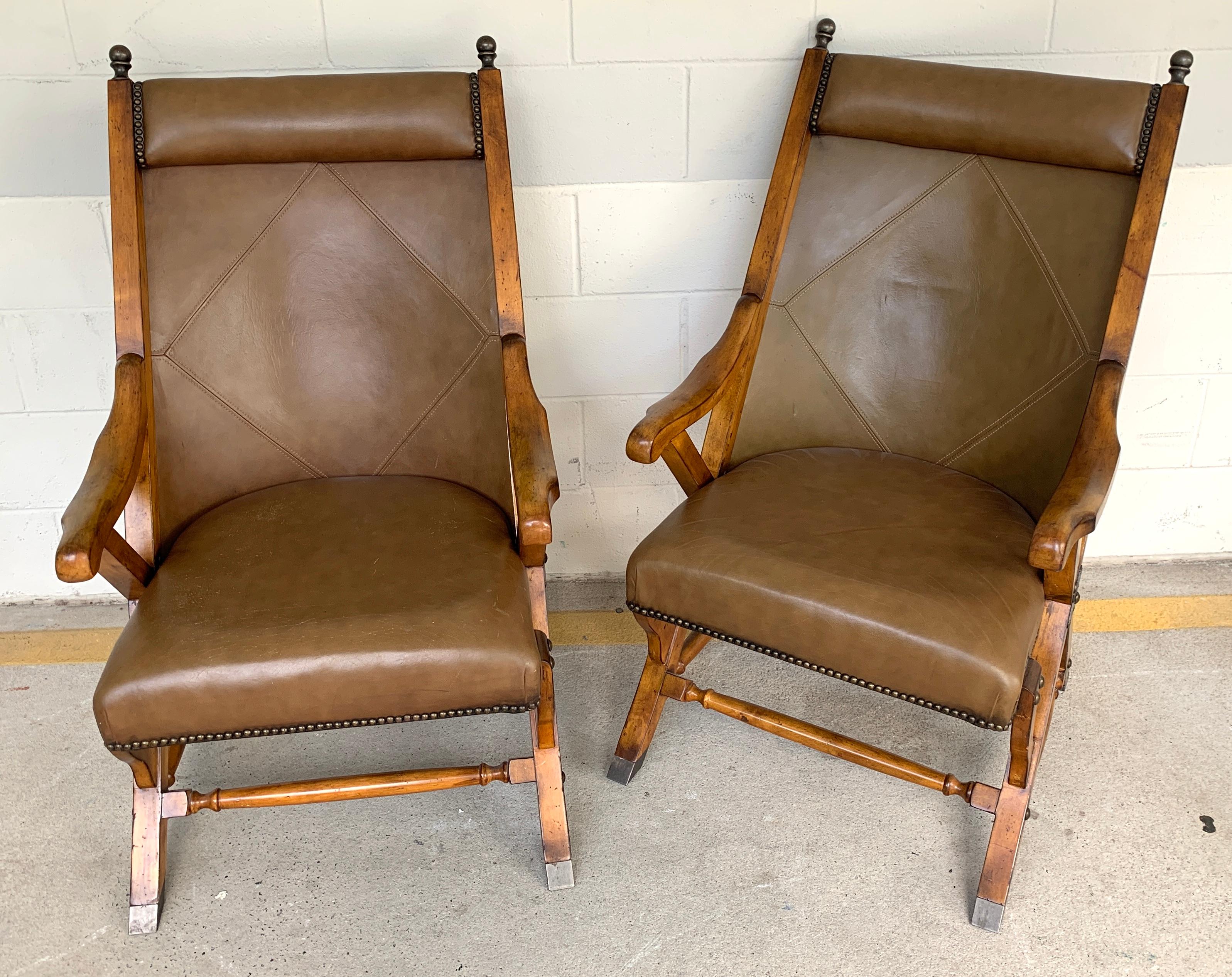 Pair of English Campaign style chair elm and leather chairs, Each one with stitched leather backrests, raised on stationary (they do not fold) brass-mounted elm frames. 24