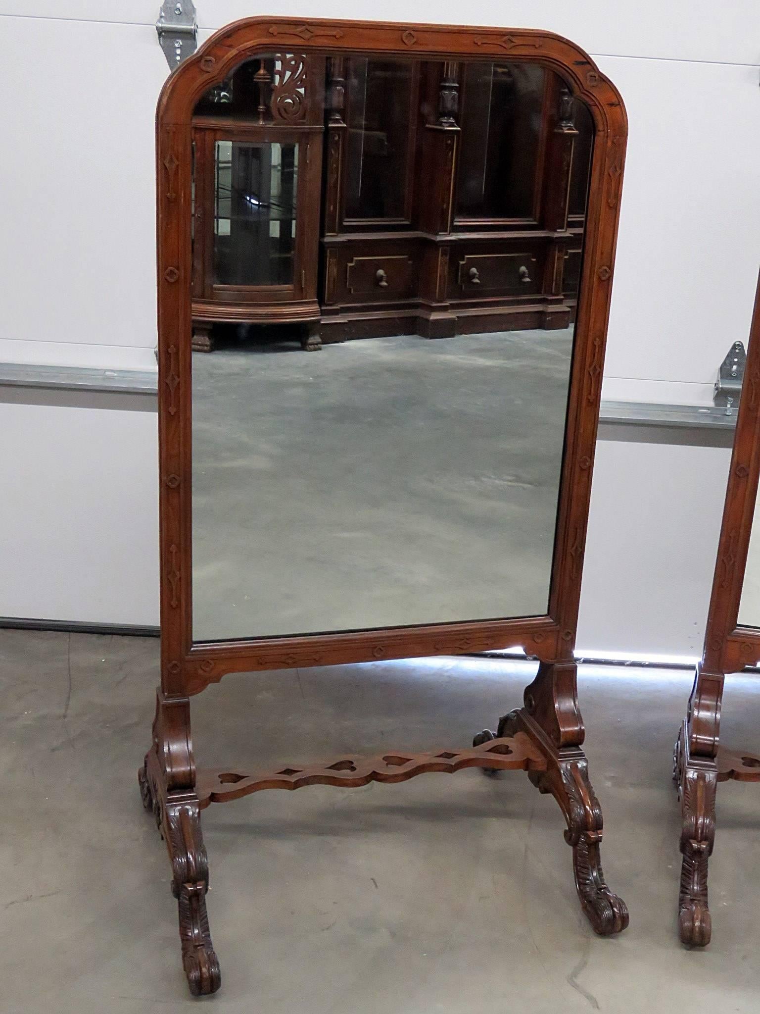 Pair of English early 20th century carved walnut standing mirrors.