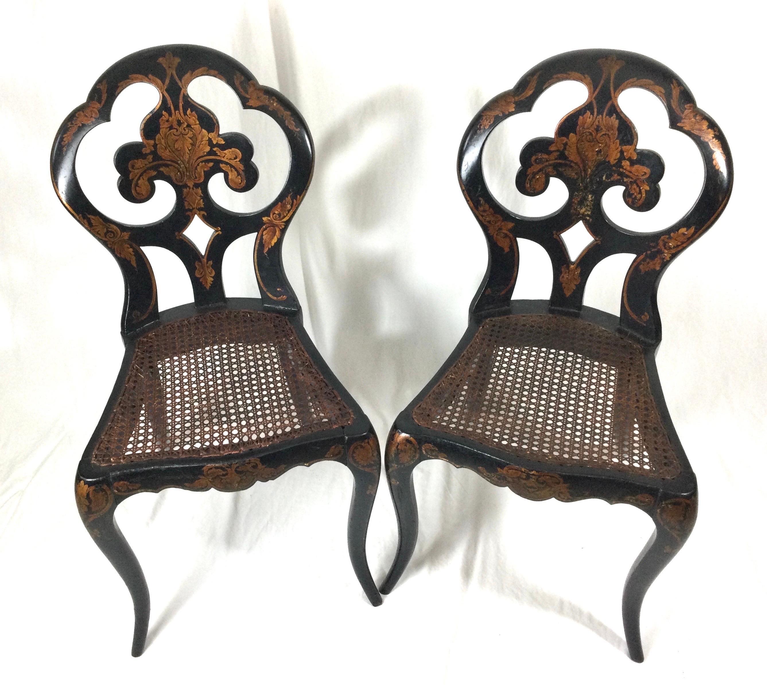 Charming pair of diminutive English lacquered wood hand painted chinoiserie chairs with cane seats. With shield backs and gracefully curved legs with hand decorated details, circa 1870.
Dimensions: D 14
