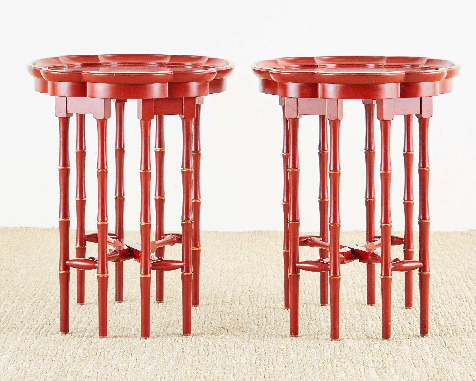 Red lacquered pair of tray tables made in the English chinoiserie taste featuring faux bamboo folding bases. The tray tops are decorated with idyllic Asian motif scenes and have a galleried edge. The tables have a parcel-gilt finish on tops and