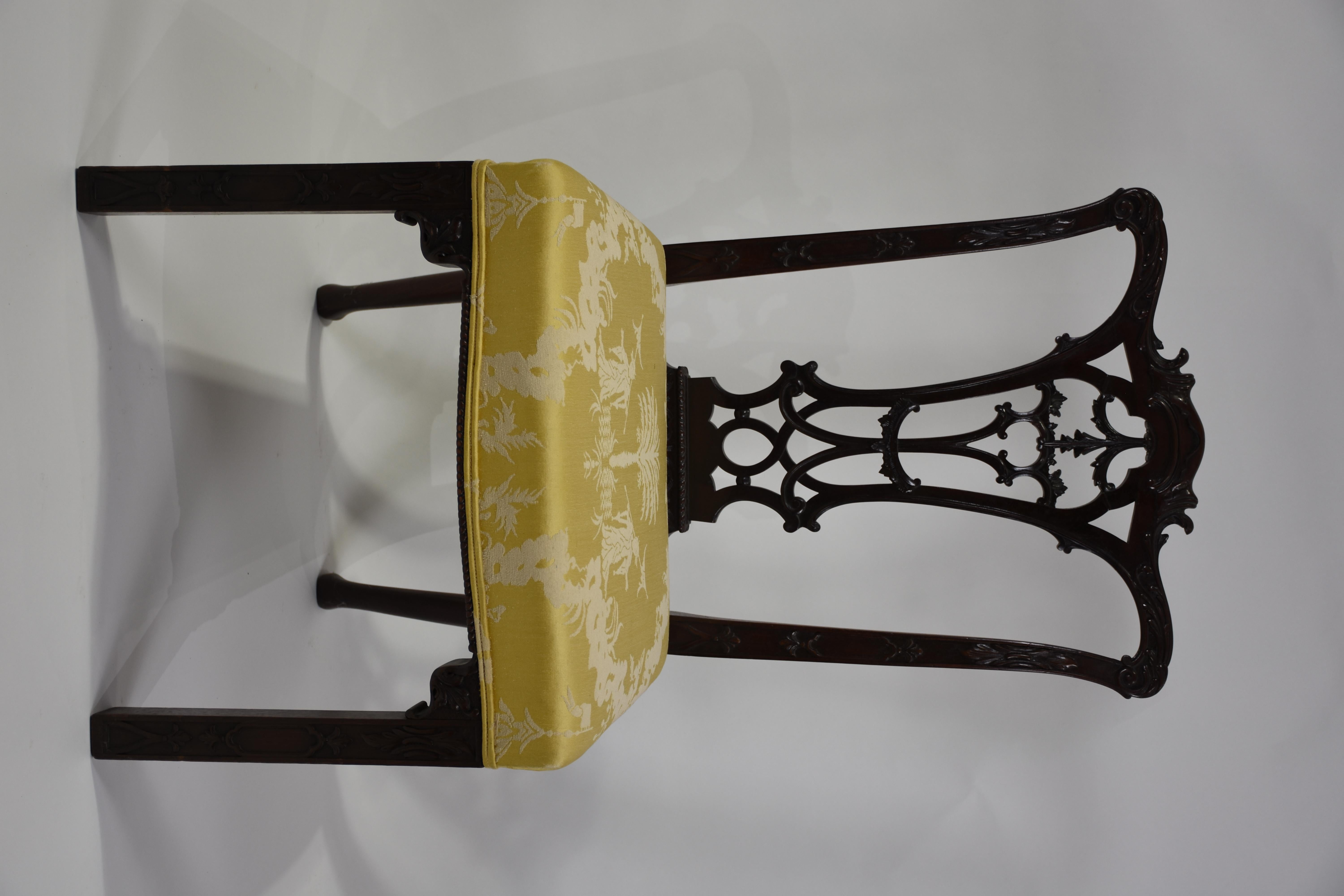 Une paire exceptionnelle de chaises d'appoint classiques de style Chippendale, finement fabriquées en acajou massif et recouvertes d'un luxueux damas de soie. Fabriquées en Angleterre, ces chaises élégantes reflètent l'influence durable de la