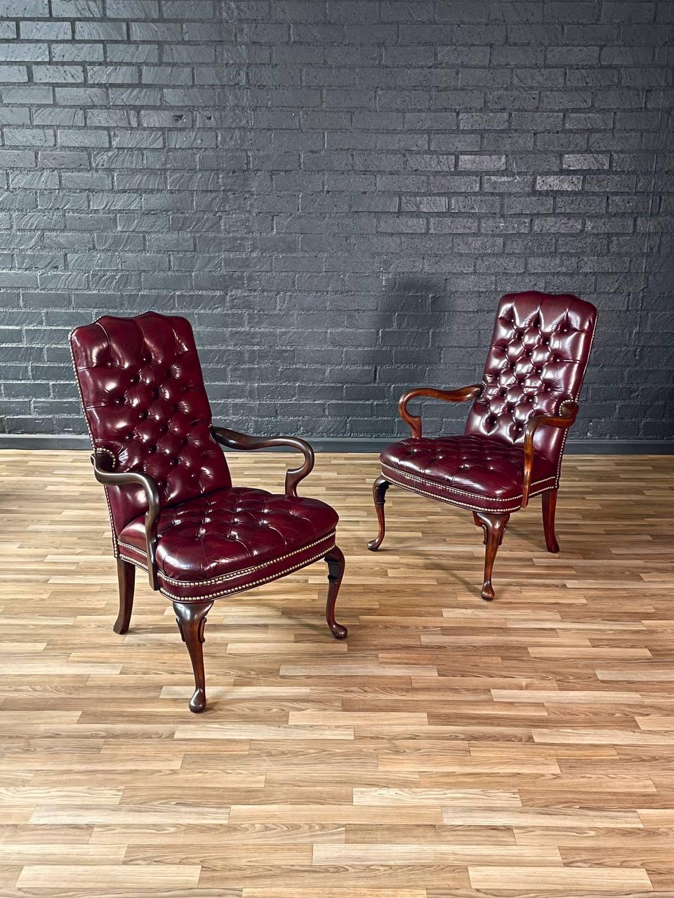 Materials: Original Burgundy Leather, Brass Nailhead Trim, Walnut-Stained Maple

Elevate your space with this exquisite pair of Chippendale-style armchairs, crafted from rich walnut-stained maple  and upholstered in deep burgundy tufted leather. The
