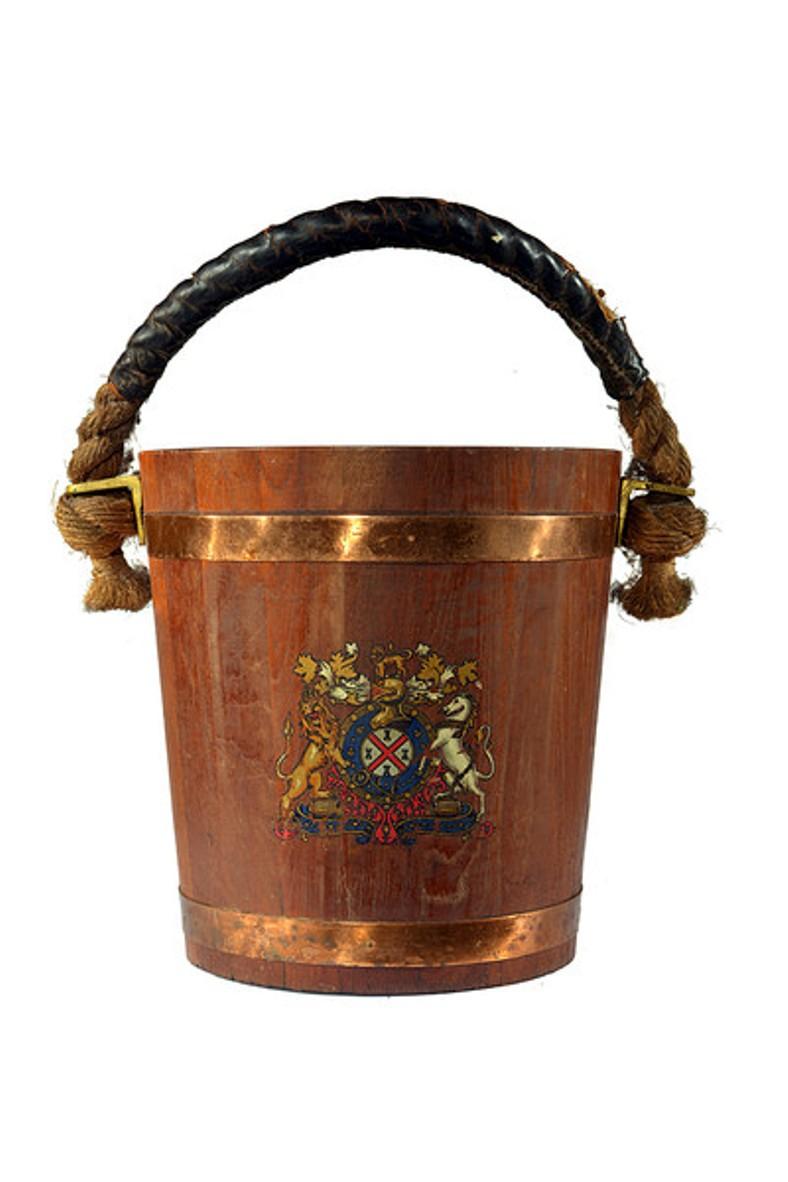 A pair of substantial English oak fire buckets with copper strapping, a central coat of arms and a thick twisted leather bound rope handle.
Each with a removable zinc bucket.