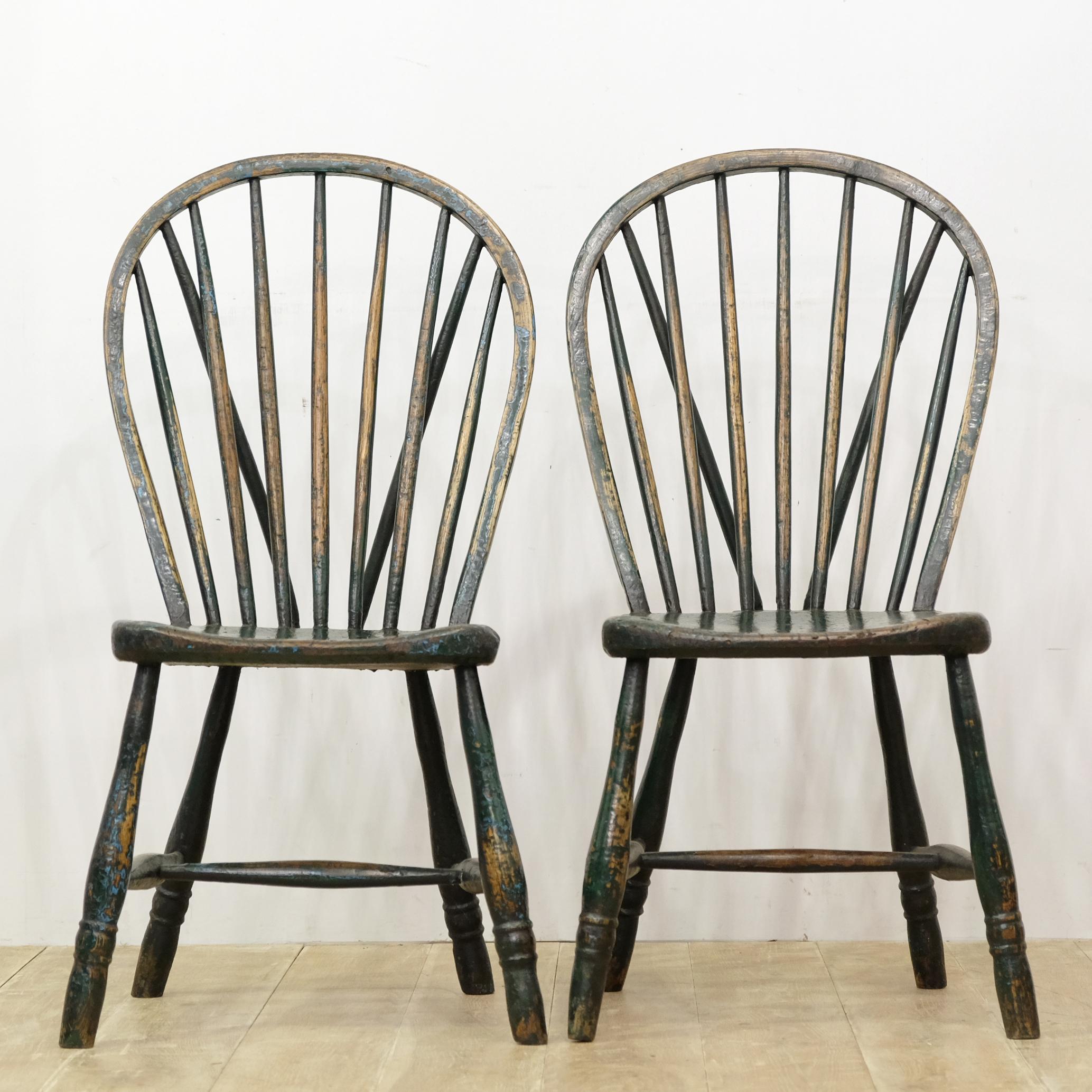A good pair of West Country side chairs in layers of old paint. Decoratively turned legs with egg and reel pattern, united by a tapered H stretcher. Solid elm slab seats, shaped in a pleasing manner with lots of fetching smooth wear, both to the
