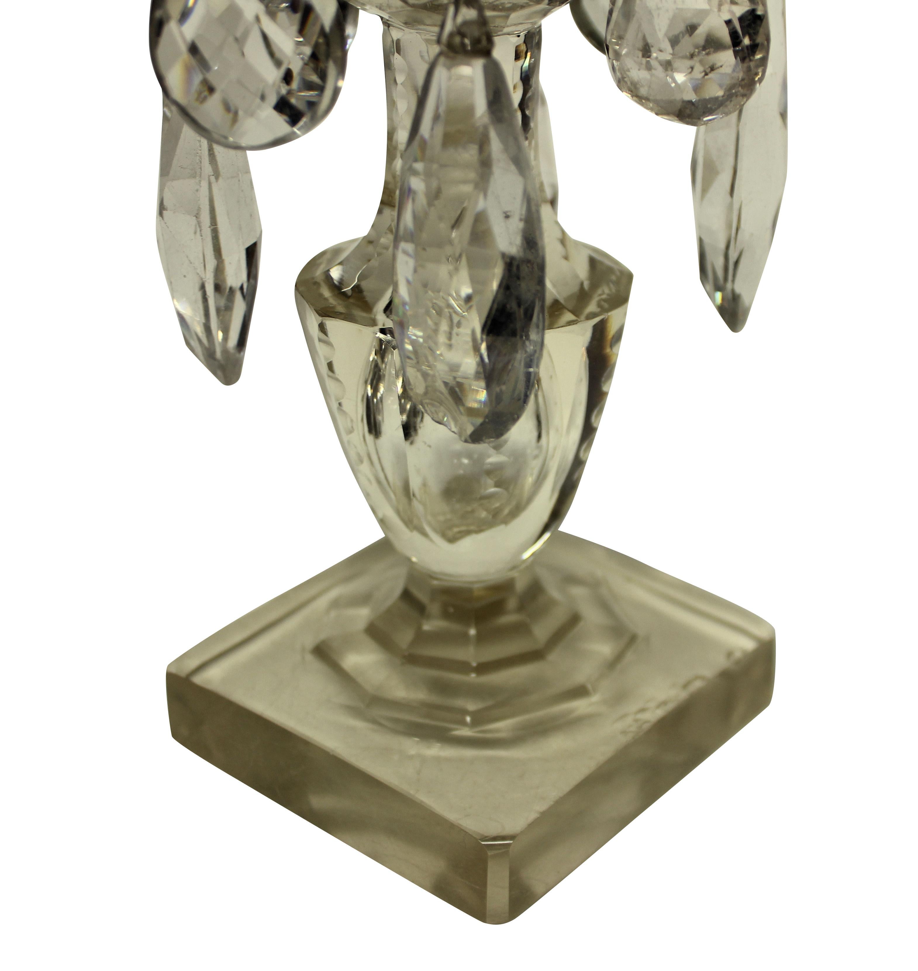 Une paire de chandeliers anglais en verre taillé. Les tiges principales dans un verre légèrement teinté de citron.