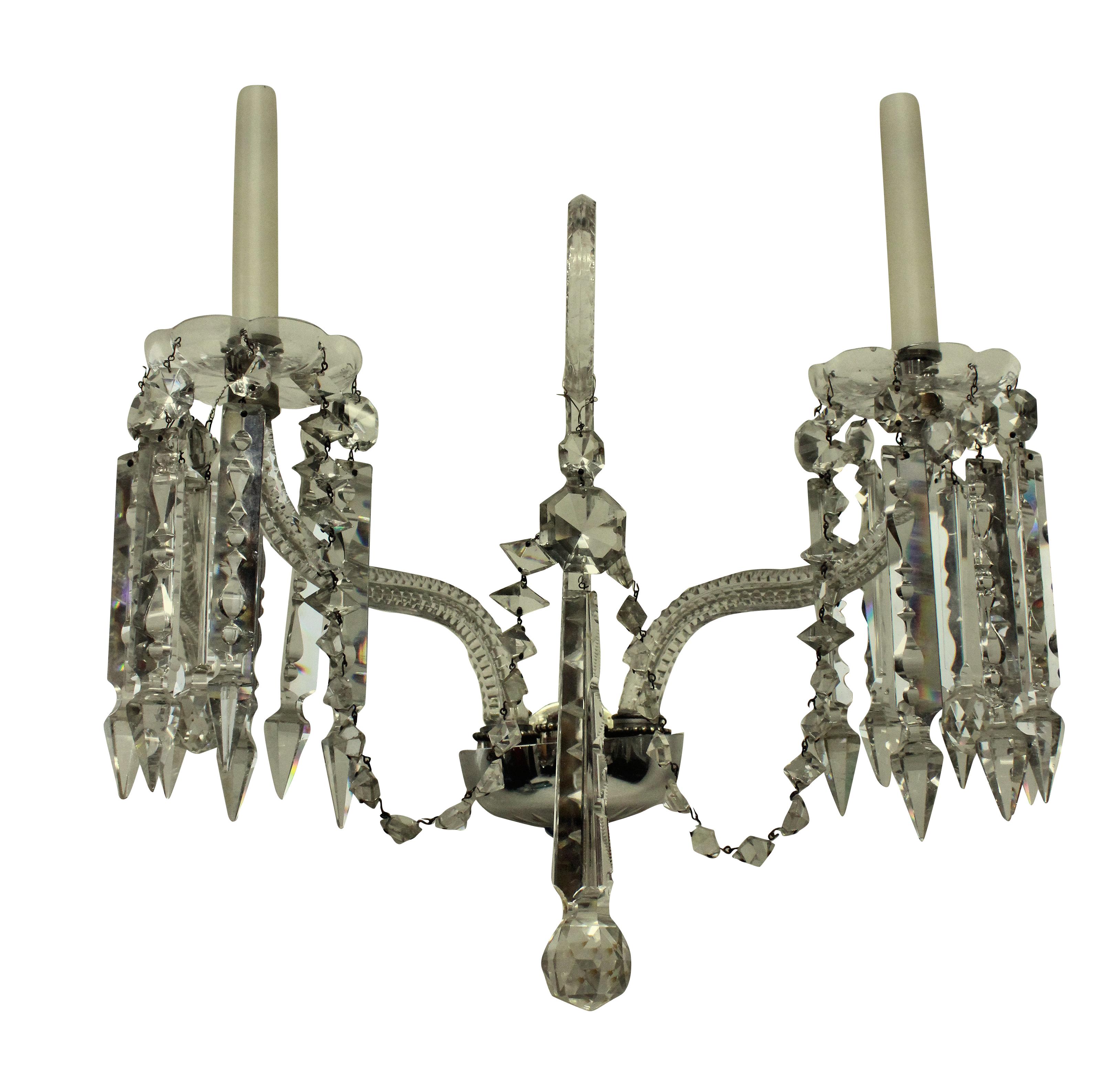 A pair of English cut glass, twin branch wall lights, with a central scroll.