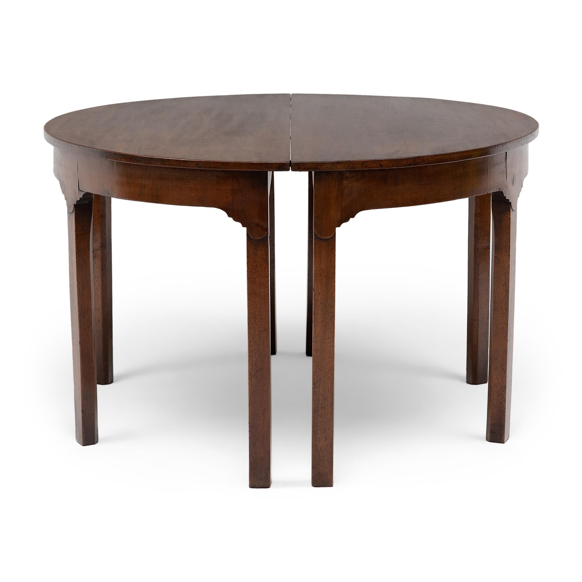 Quiet and refined, this pair of 19th-century English demi-lune tables blends effortlessly into any interior. The tables are crafted of mahogany with a minimalist form that pulls from Georgian, English Country and French Provincial styles. Each table
