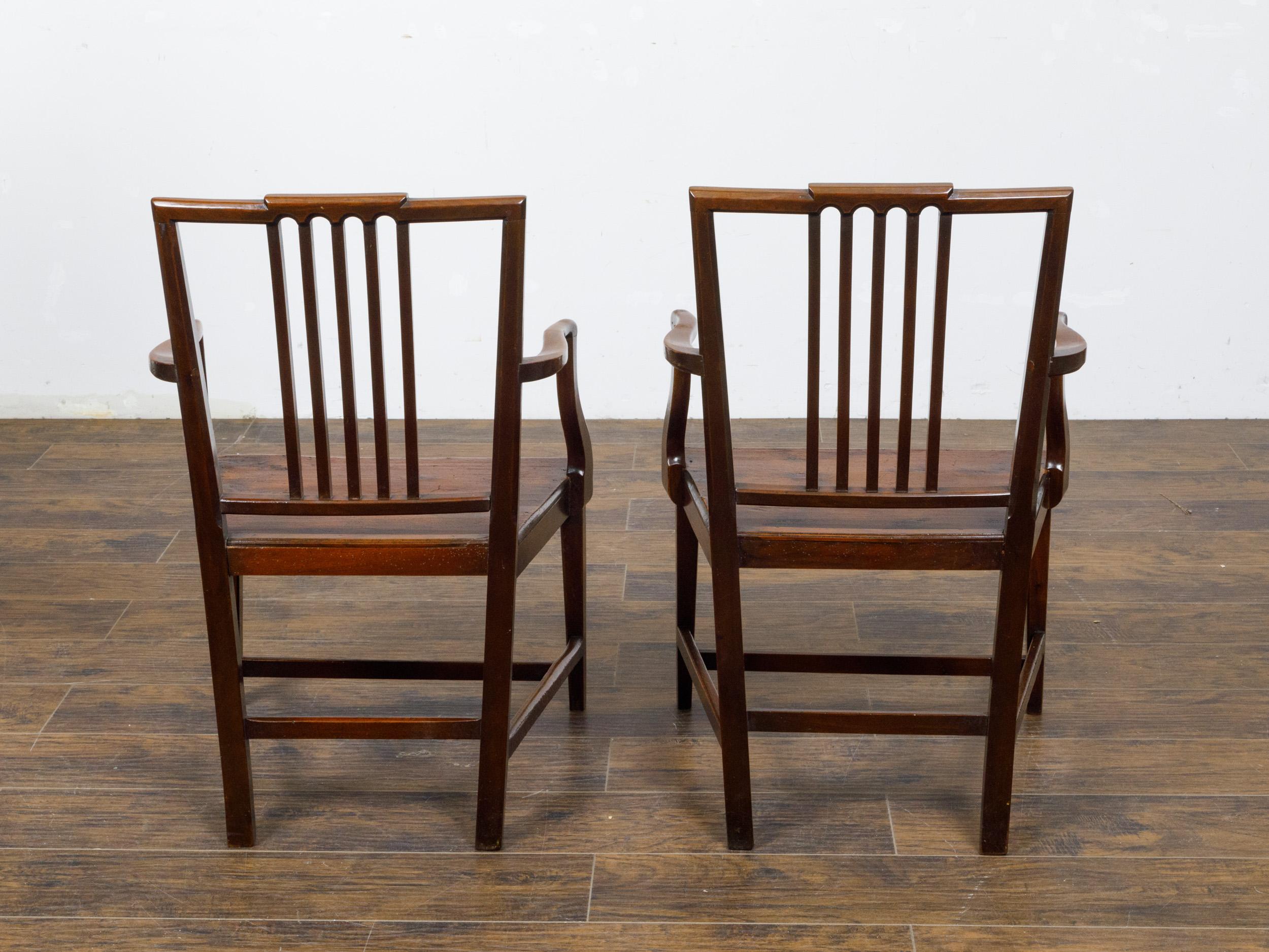 Carved Pair of English Early 19th Century Plank Seat Chairs with Scrolling Arms For Sale