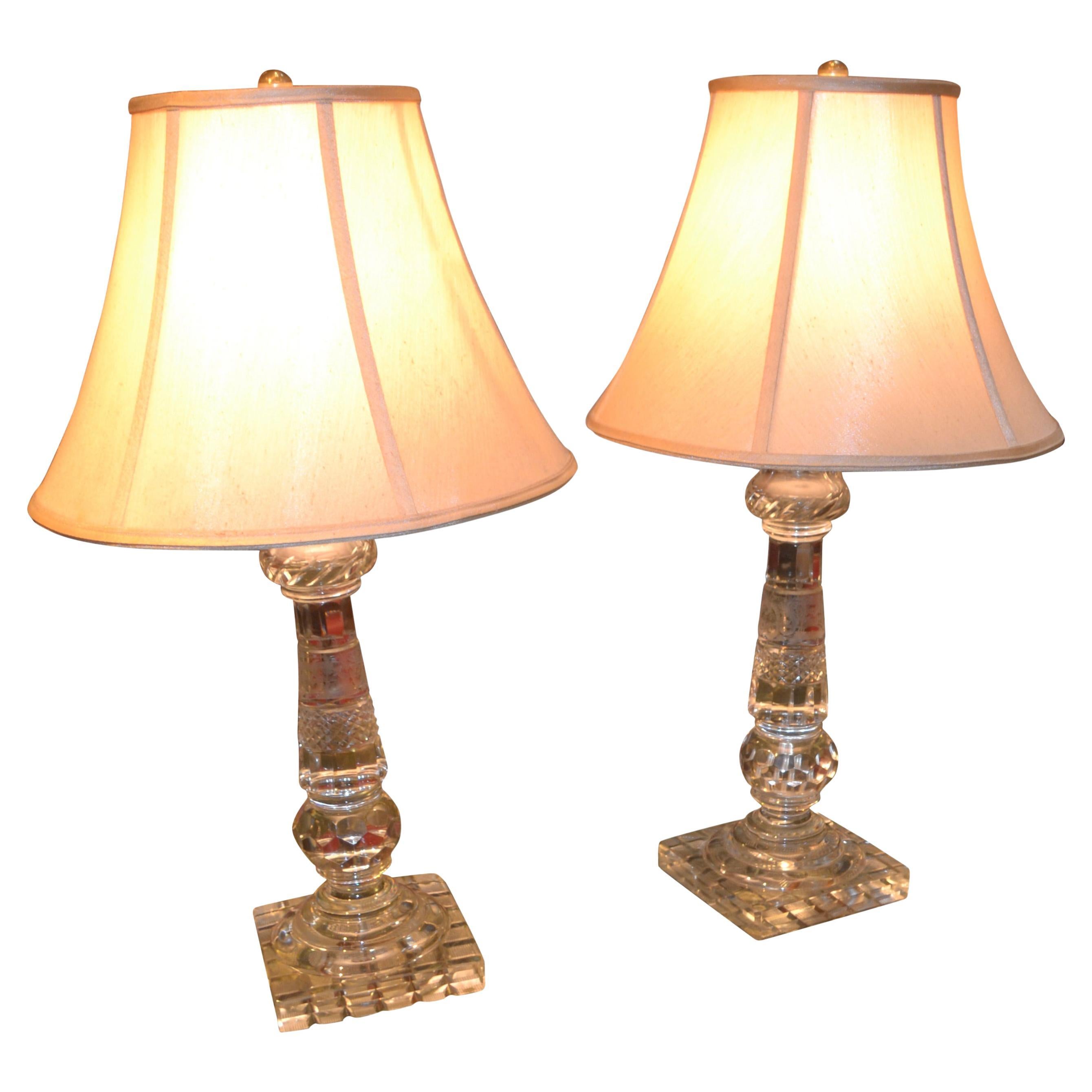 A pair of heavily cut crystal lamp bases; the stems cut in various designs; the bottom of the rectangular bases are also heavily cut.