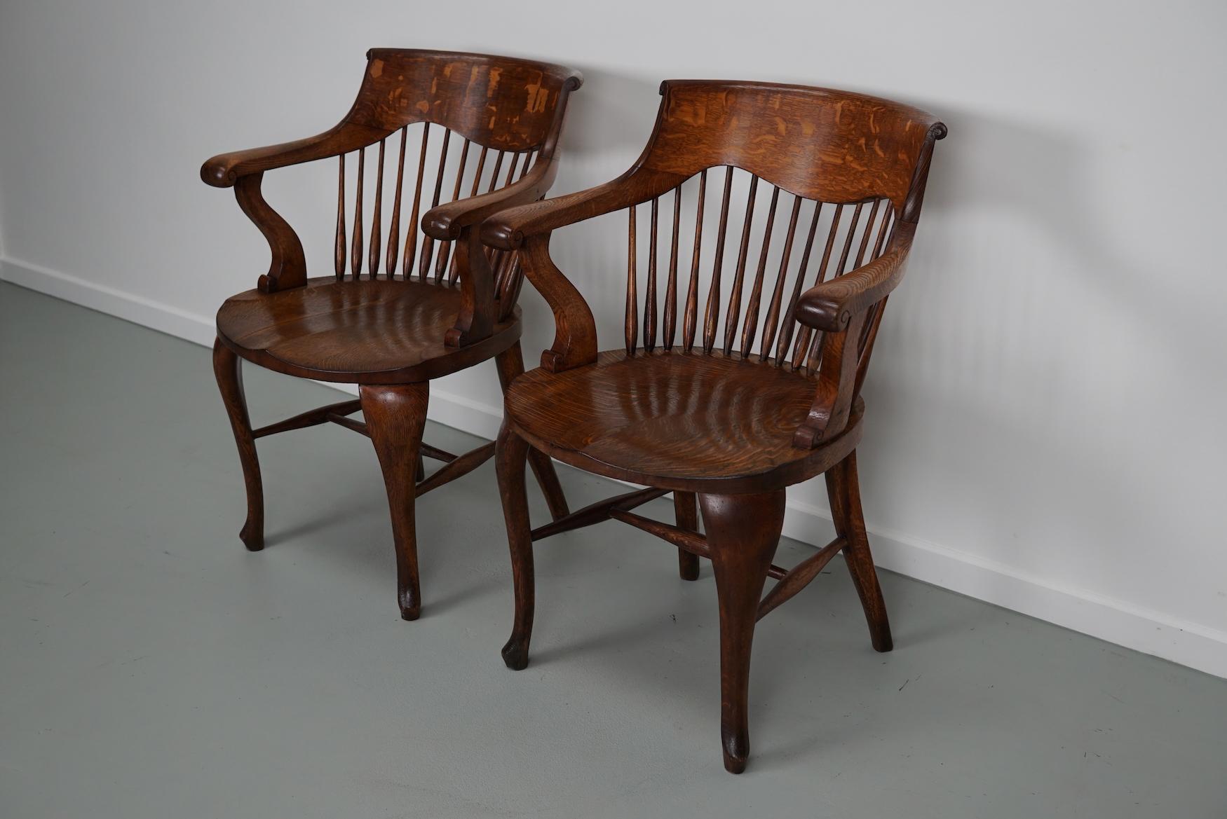Cette paire de chaises de bureau édouardiennes a été fabriquée au début du XXe siècle en chêne de très belle qualité. Ils sont en bon état stable et ont une très belle couleur chaude.