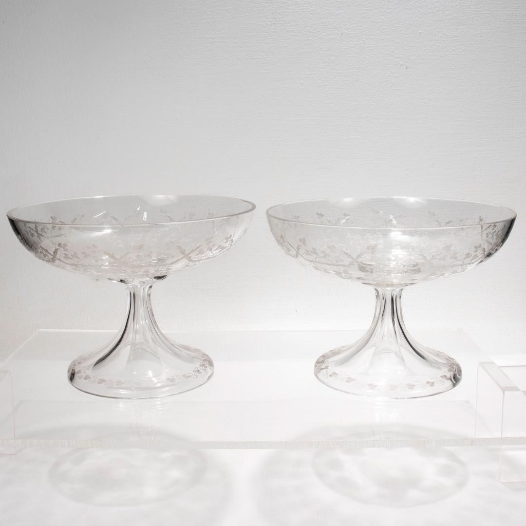 A fine pair of handblown English glass footed bowls.

Attributed to Stevens & Williams or Webb.

Each with a panel-cut pedestal with engraved vine decoration supporting a bowl with stylized etched trelliswork and ivy or grape leaf