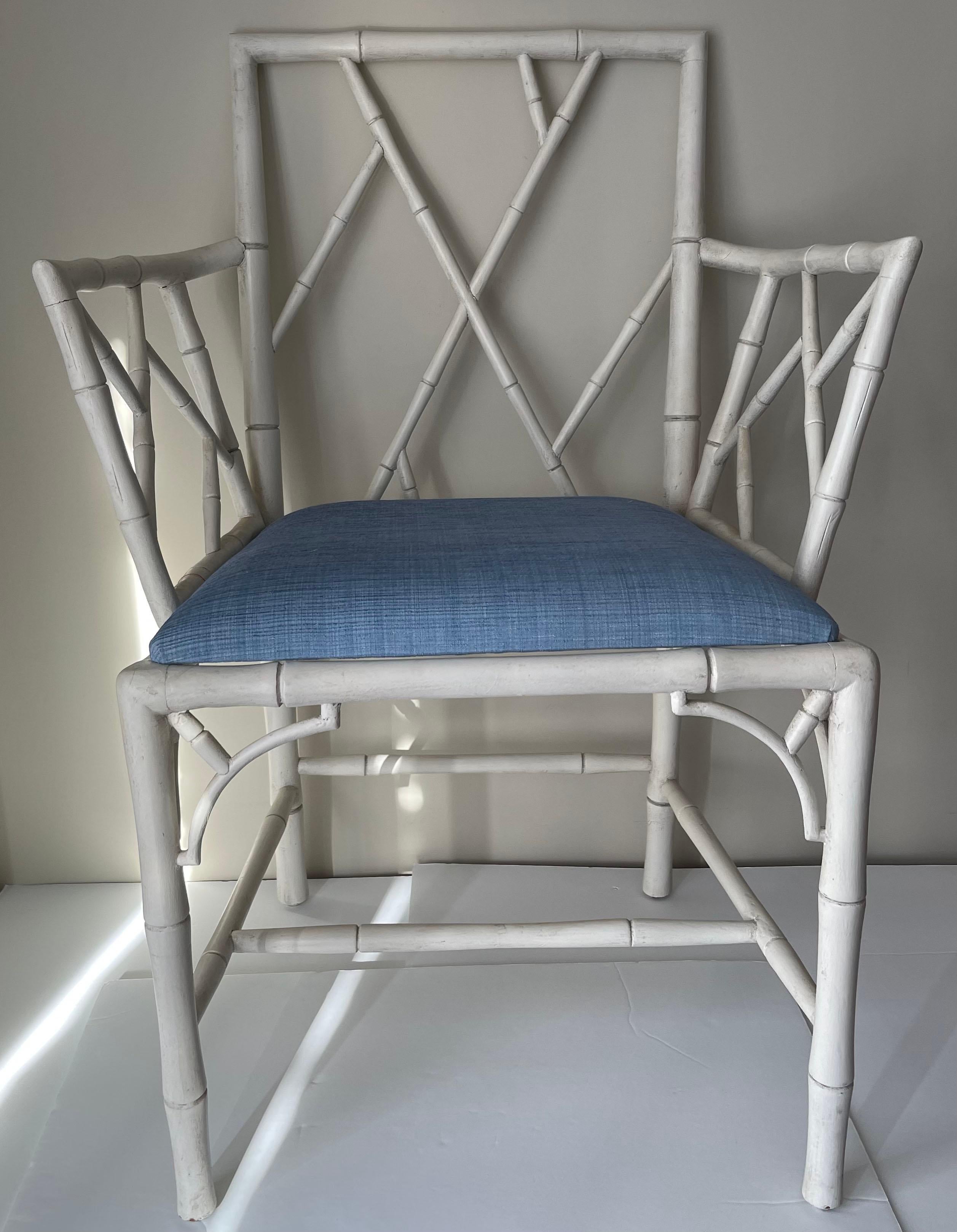 Paire de fauteuils anglais des années 1940 en faux bambou. Récemment peint dans une finition blanche antique. Nouvellement tapissé en tissu Schumacher en coton tissé bleu clair. Le tissu apparaît légèrement plus foncé sur les photos.