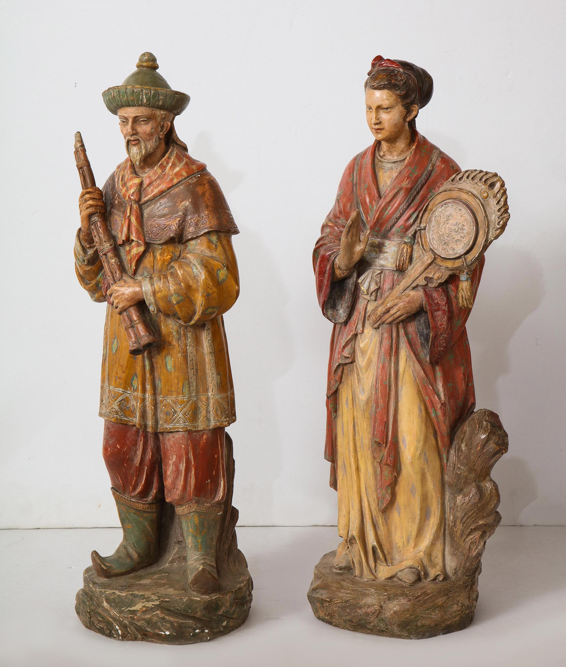 The pair of English ceramic figures showing a Chinese man and woman in traditional costume each holding a musical instrument.