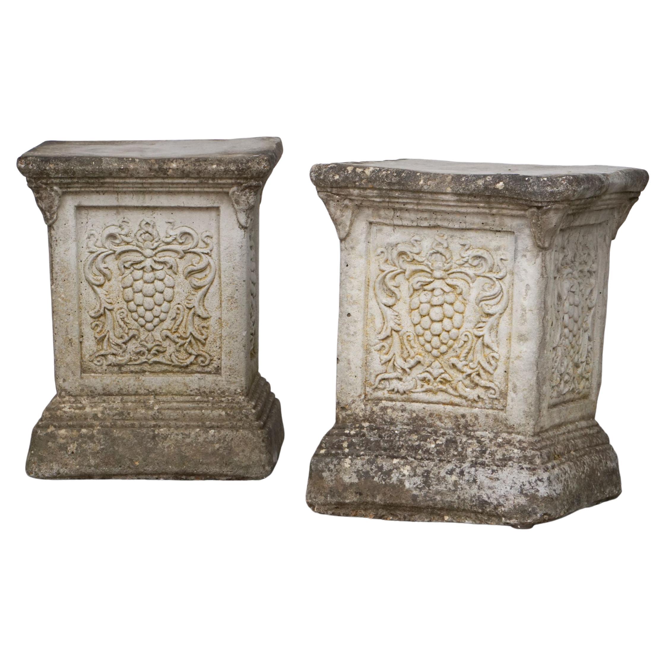 A fine pair of English garden plinths or pedestals of composition stone for use as an ornamental garden feature or display pedestal. Each plinth featuring a square top over four sides with a relief of grapes on each panel.

Individually priced -