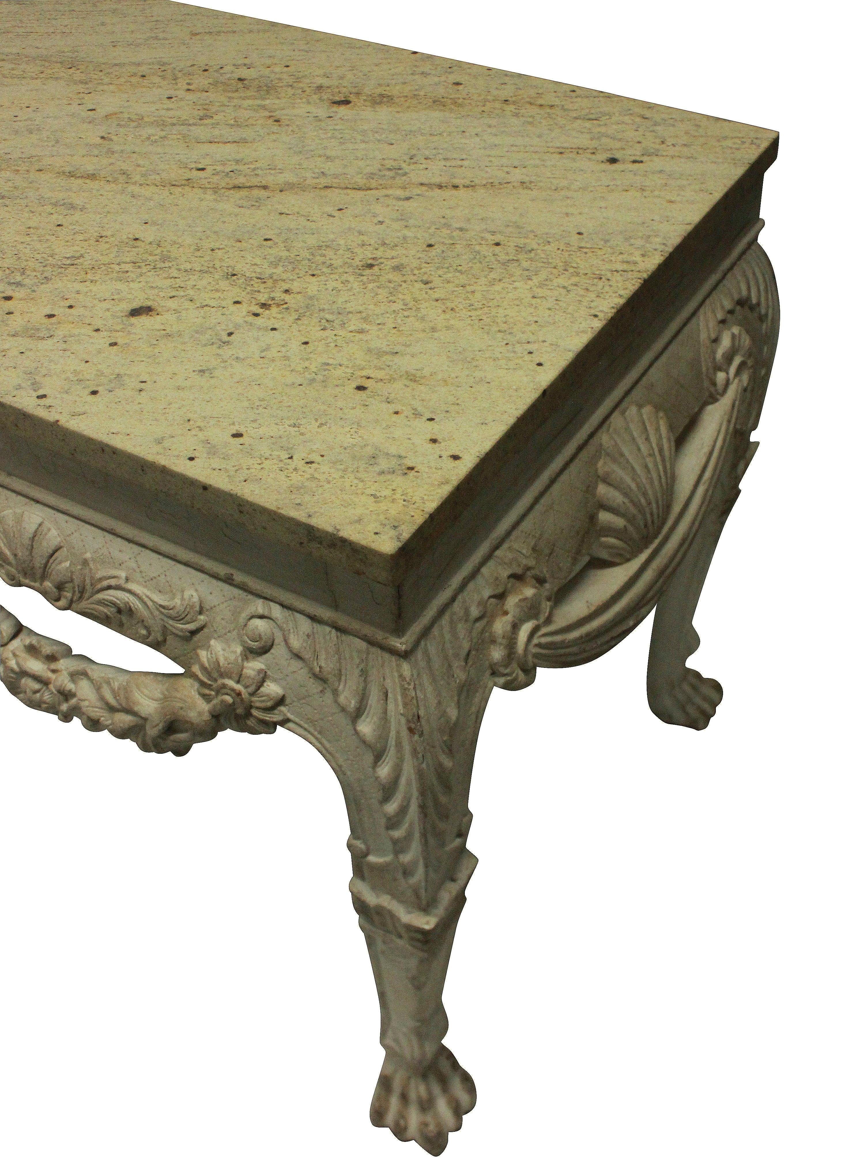A large pair of English country house console tables in the 18th century manner, with lion masks, swags and acanthus carvings. Distressed painted mahogany with stone colored marble tops.

 