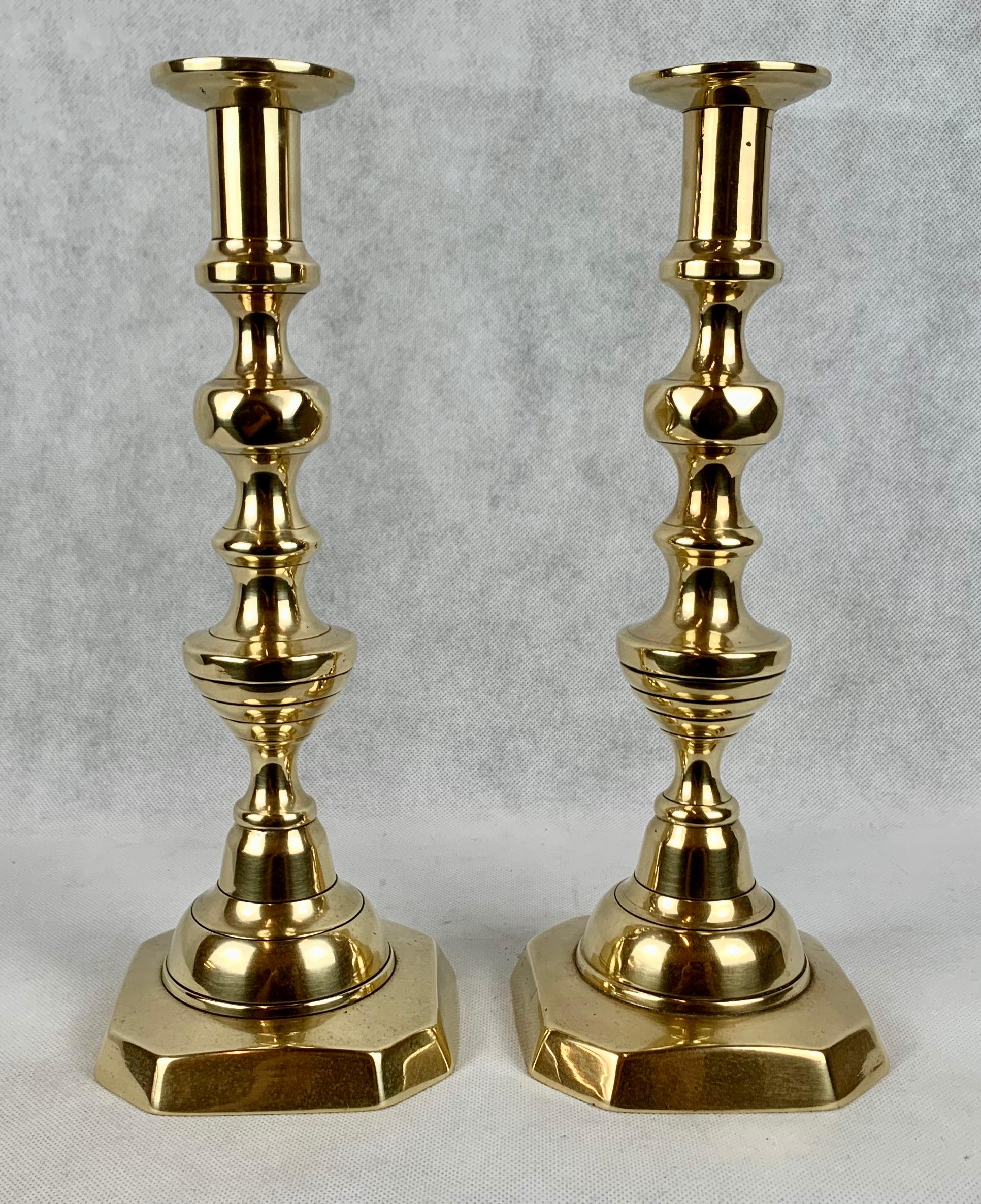 English A Pair of Diamond and Beehive Push-Up Brass Candlesticks, 12
