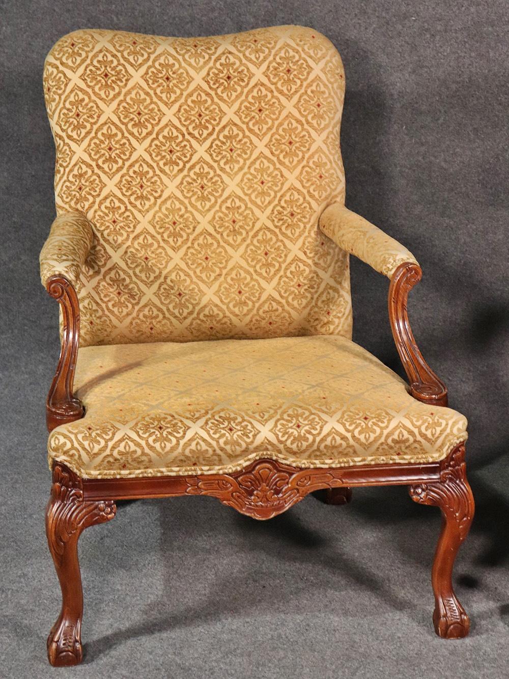 Pair of English Georgian style carved walnut lounge chairs with textured upholstery.
