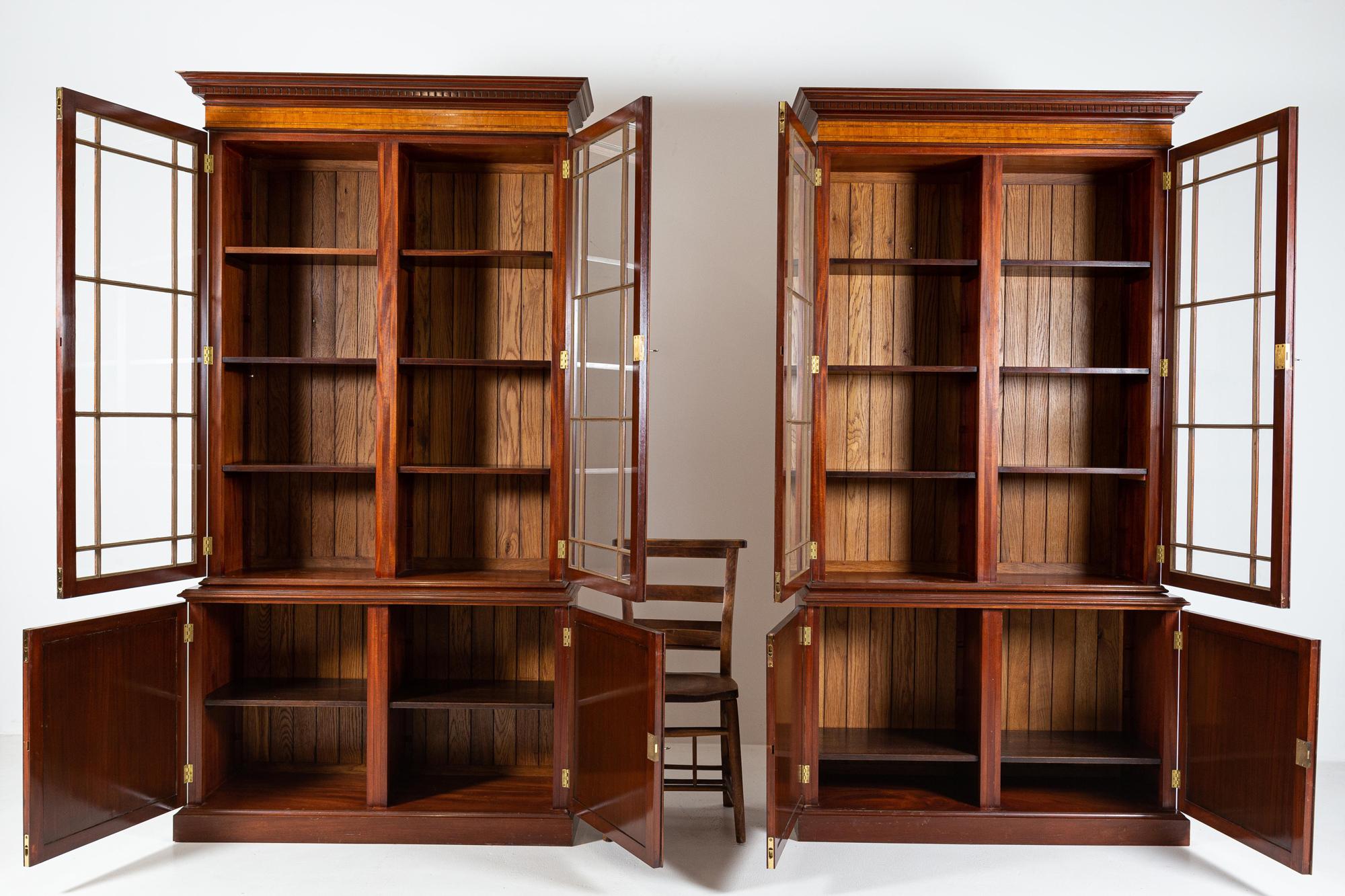 Circa 1920.

A Matching Pair of Fine Quality English Glazed Inlaid Mahogany Bookcases with Panelled Doors and Oak Panelled backs.

3 keys with original hardware.

Price is for the pair

sku 772

W116 x D40 x H216cm

