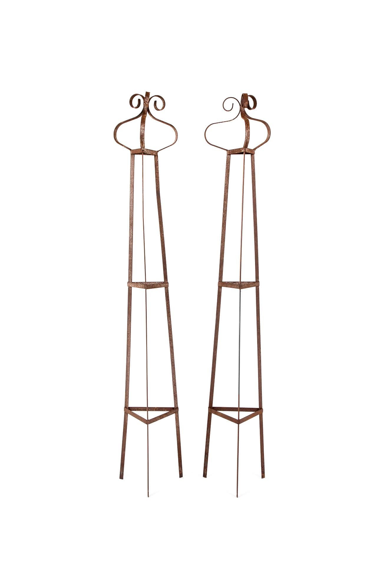 A grand pair of forged wrought iron obelisks of triangular form with turned scrolled finials.

Salvaged from an English walled garden in north Yorkshire.

Price is for the pair.

English, mid 20th century.

H: 230 CM  H: 90.5 INCHES

W: 37.5 CM  H: