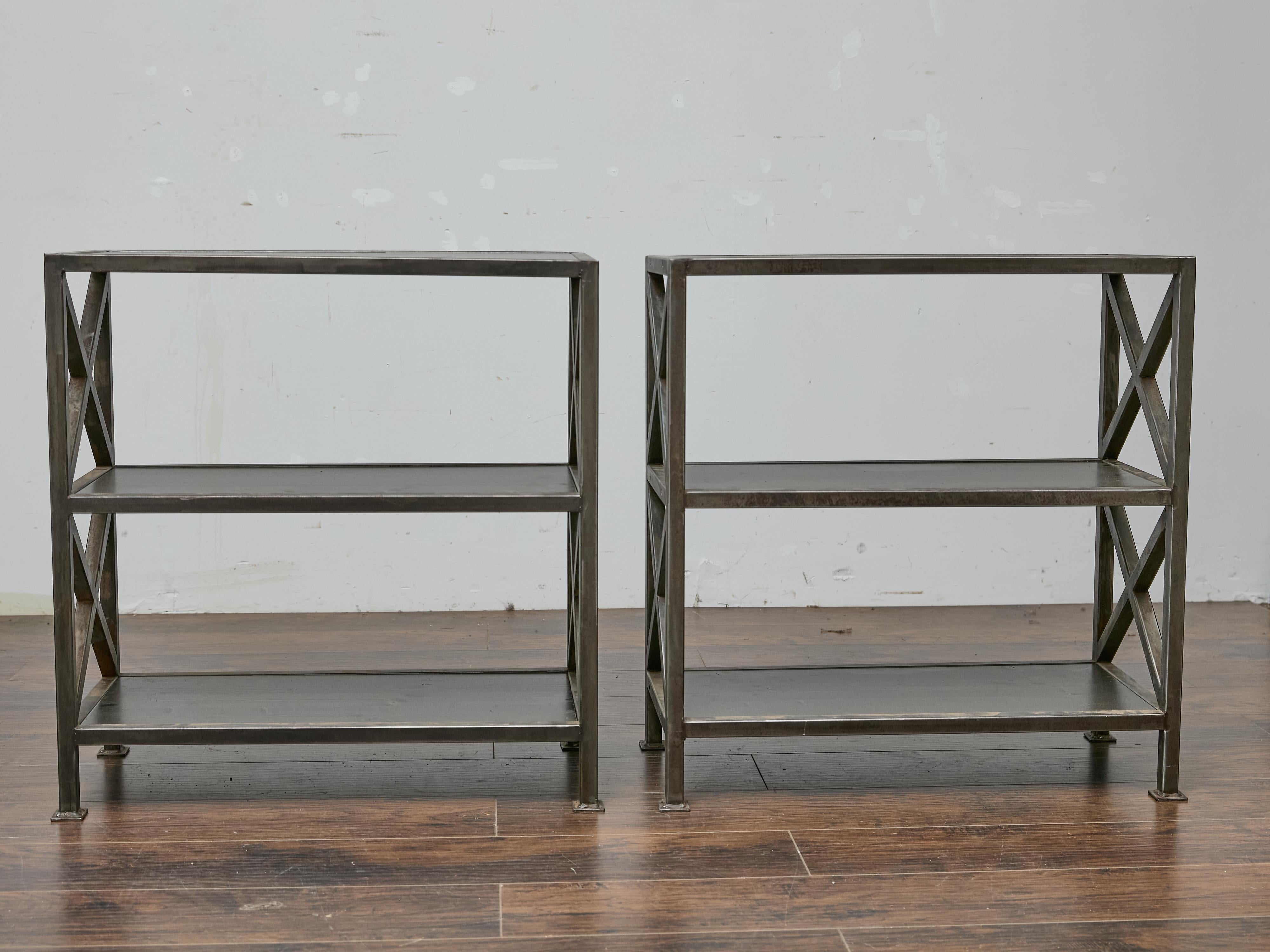 Questa coppia di étagères inglesi del Midcentury unisce la forza utilitaria a un design raffinato e understated.design. Realizzate in ferro con ripiani in legno tinto scuro, queste scaffalature sono dotate di supporti laterali a X che aggiungono