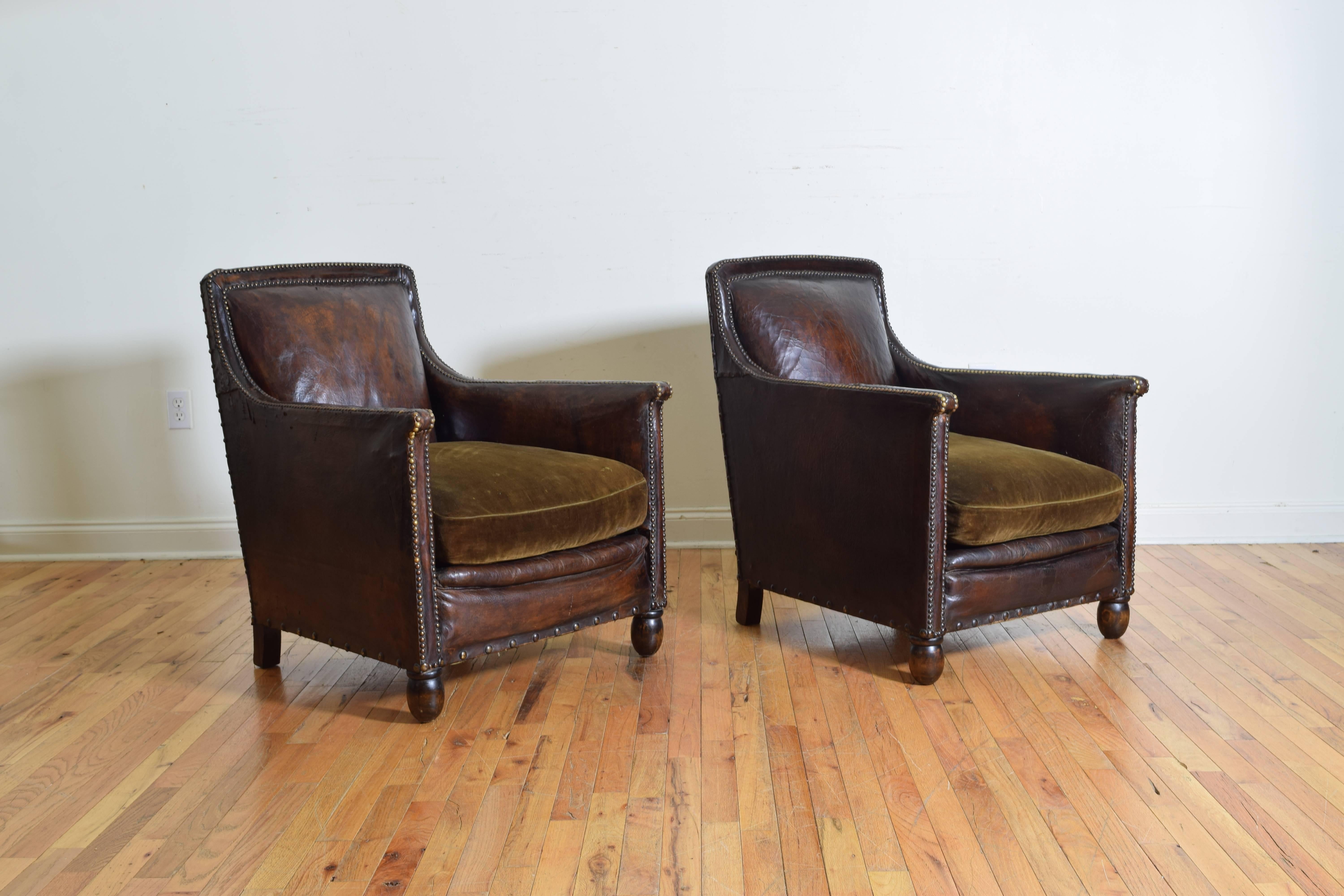 The leather in near perfect condition and trimmed in patinated brass nailheads, velvet cushions, sit comfortably, raised on acorn shaped turned walnut feet.