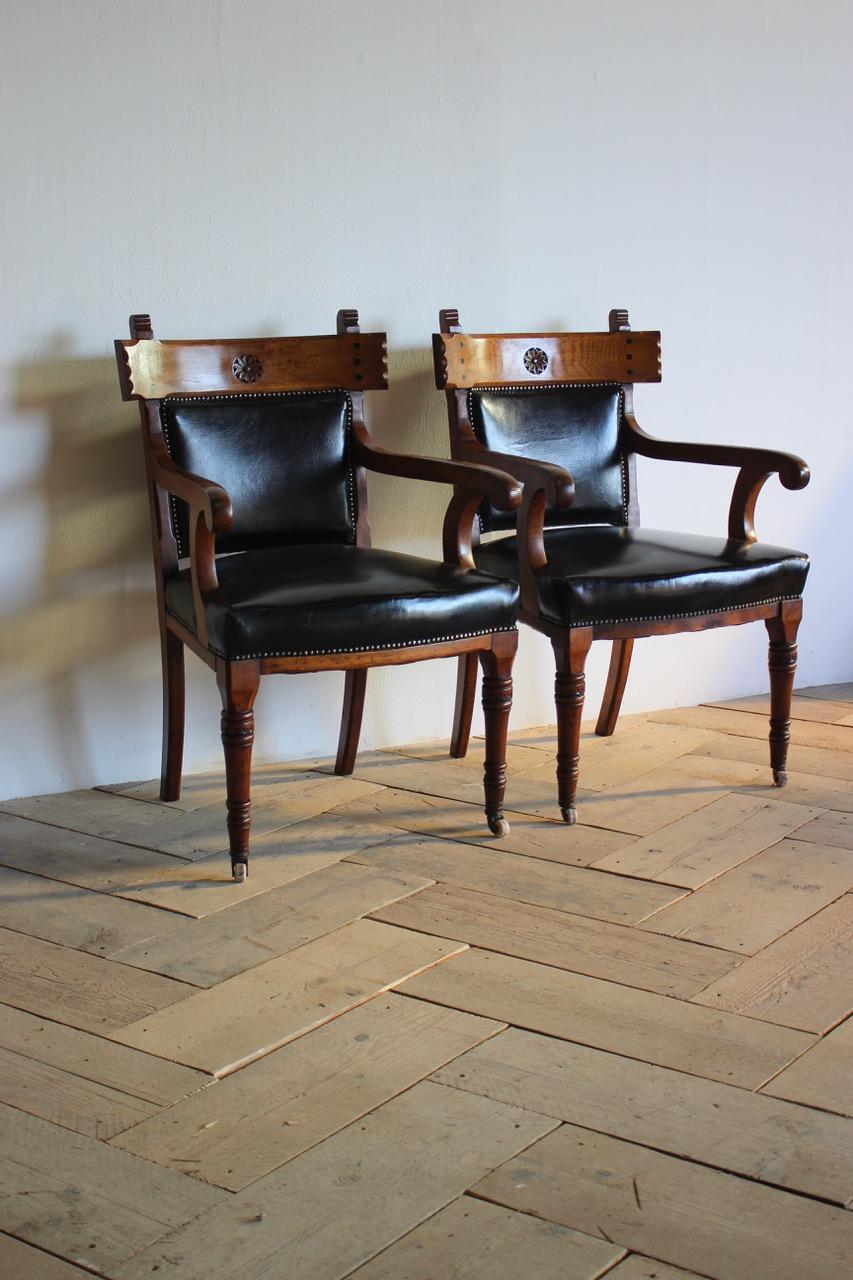 A solid pair of 19th century English library armchairs in oak, with a lovely patina, having been reupholstered in leather with studs. 
Measurements: 50 cm high (floor to seat).