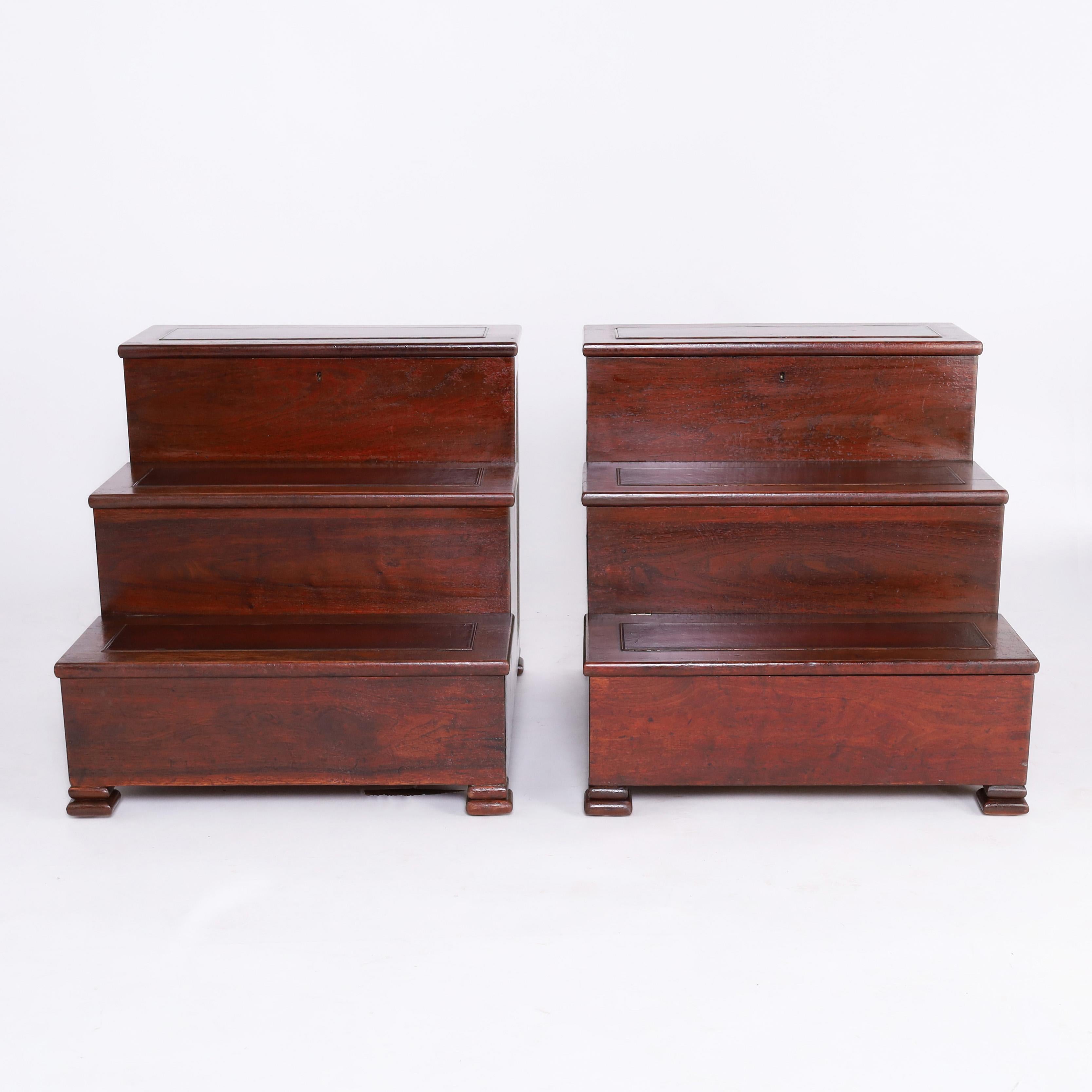 Handsome pair of 19th century English library or bed steps crafted in mahogany with three tiers having leather pads over hinged storage compartments, caned panels, and double bun feet. 