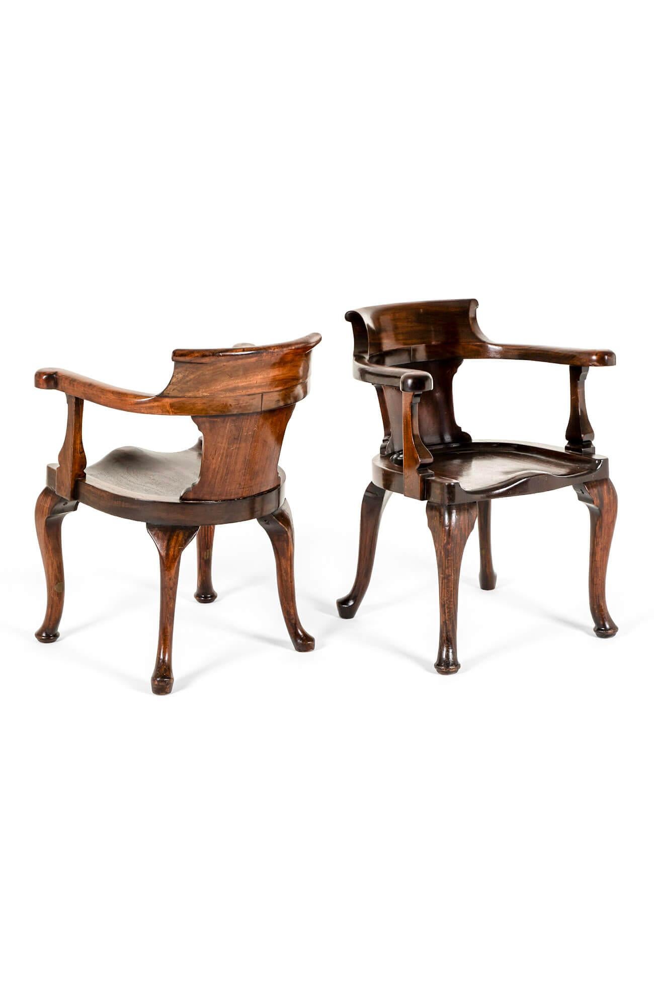 A commanding pair of mahogany Captains chairs or smokers bow armchairs with wide open arms.

Each chair has a curved top rail leading to sweeping arms with beautifully turned upright supports.

The wide shapely cut out back leads to a wide figured