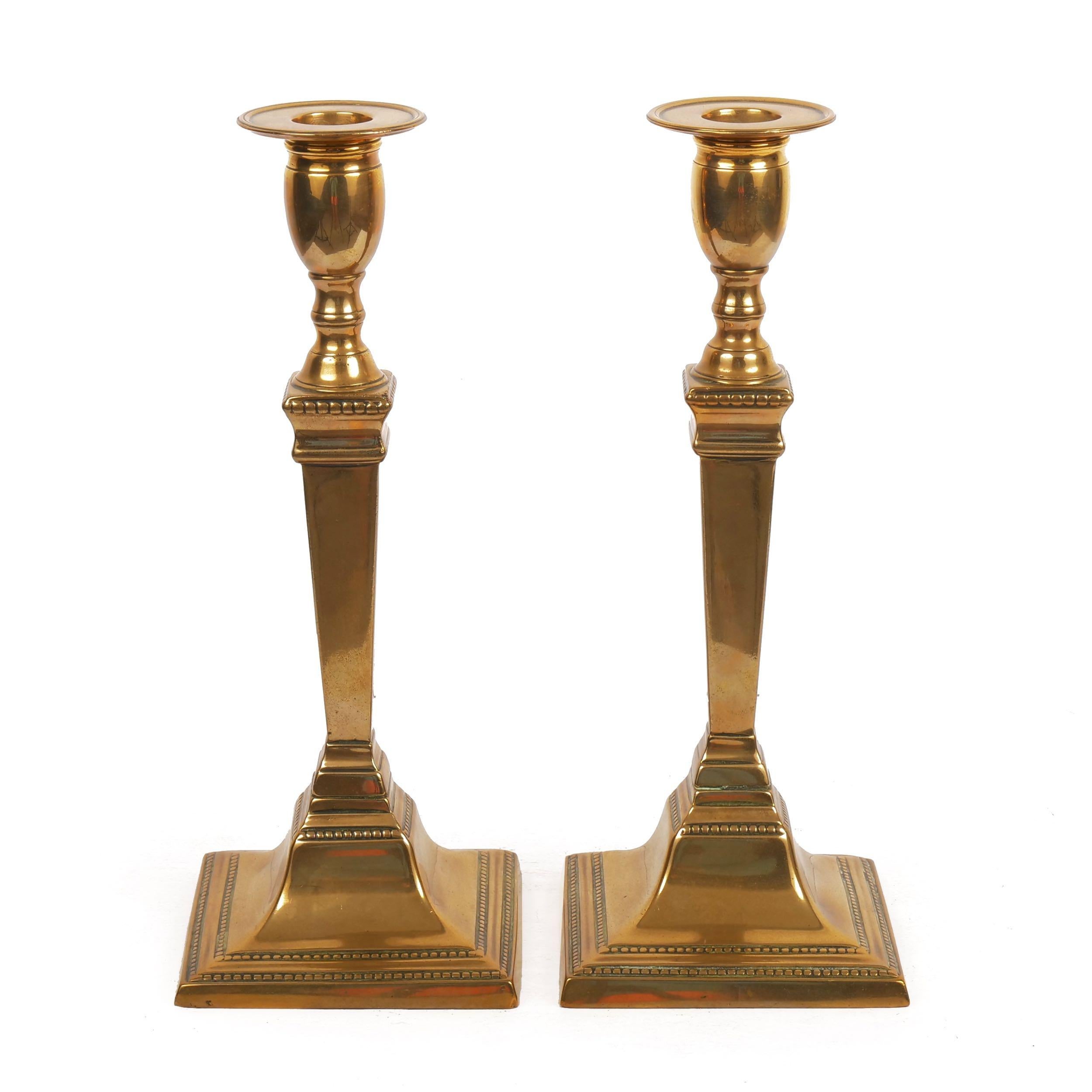 Pair of English neoclassical tapered-stem candlesticks,
circa late 18th-early 19th century
Item # C104017 

This very nice pair of neoclassical candlesticks present beautifully with simple candle-wells cast with a raised rim over a swollen