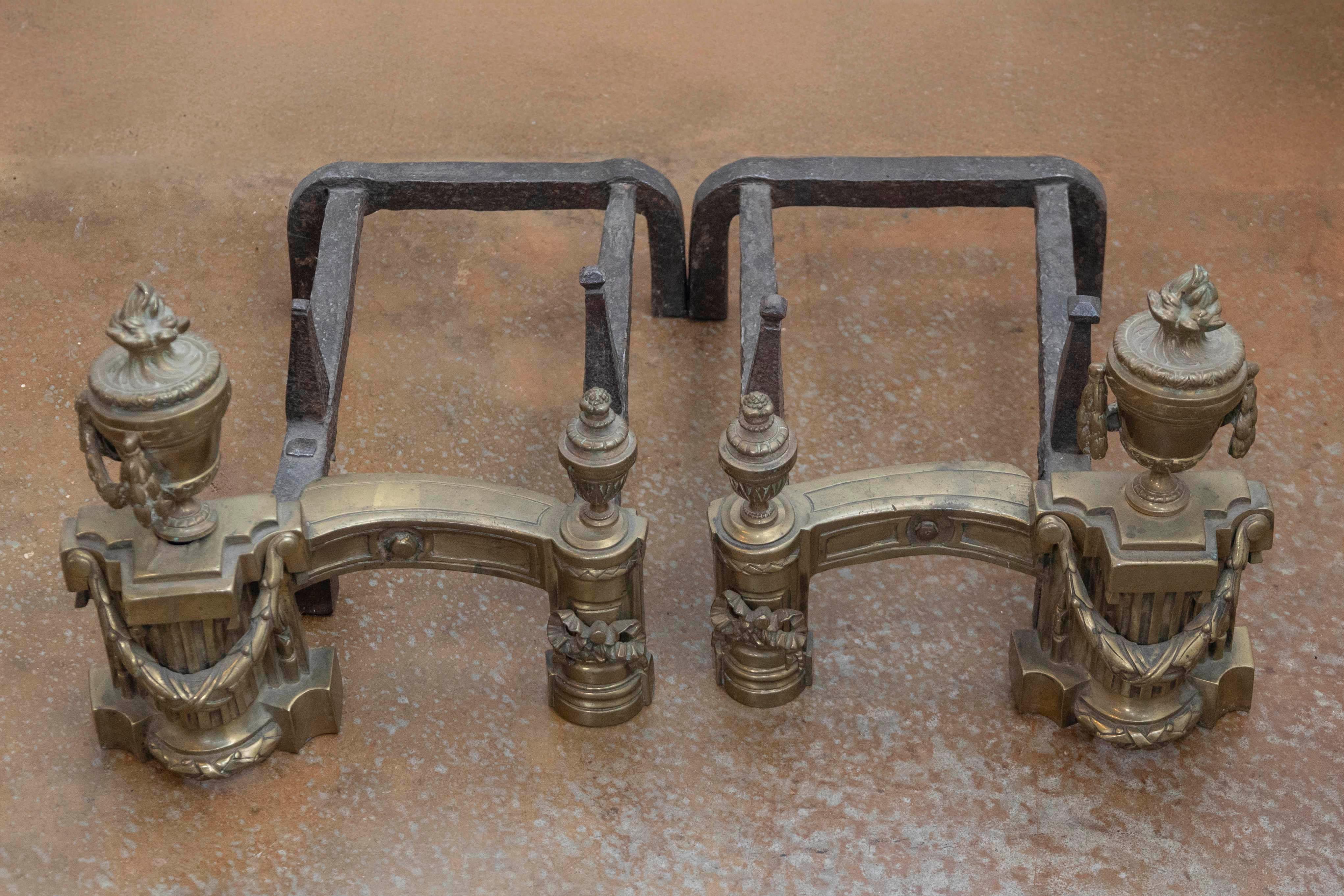 Coppia di candelabri in ottone in stile neoclassico inglese della metà del XIX secolo, con urne da fuoco e motivi a forma di rondine. Nata in Inghilterra durante il regno della Regina Vittoria, questa coppia di candelabri in ottone presenta squisite