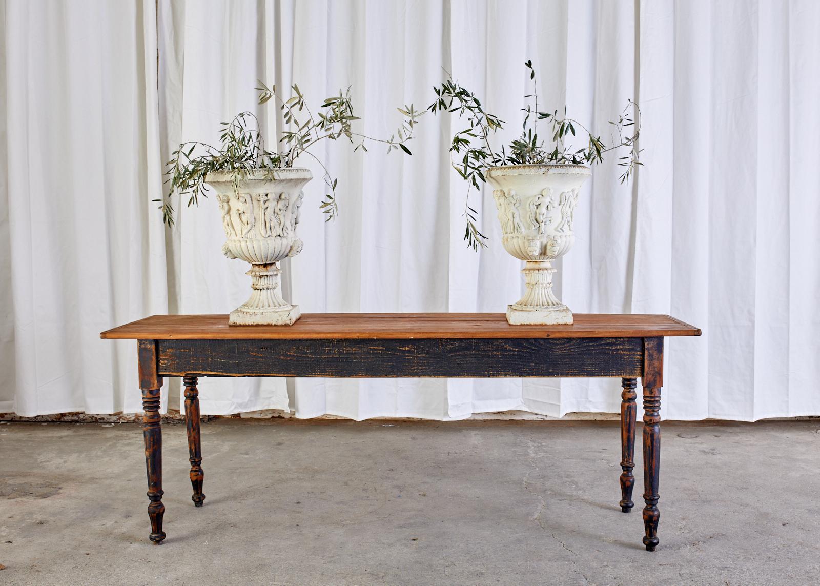 Magnificent pair of English neoclassical revival garden urns or jardinières crafted from cast iron. The urns are decorated with Greco-Roman figures with a fluted column base. Beautifully cast with an aged patina on the painted finish. From an estate