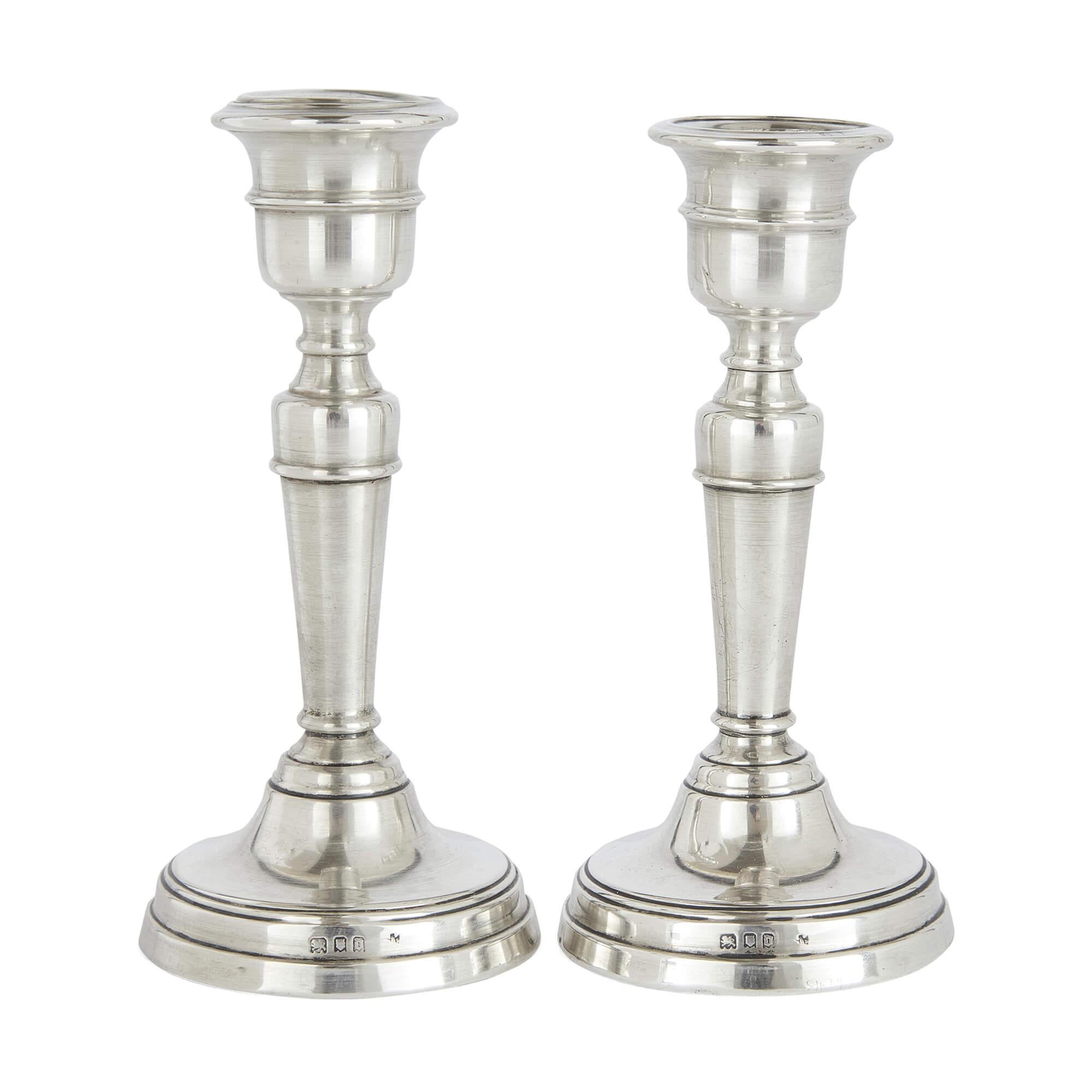 Coppia di candelieri d'argento in stile neoclassico inglese di Edward Barnard & Sons
Inglese, 1919
Altezza 13 cm, diametro 16 cm

Questa elegante coppia di candelieri, realizzata dallo stimato argentiere inglese Edward Barnard & Sons nel 1919,
