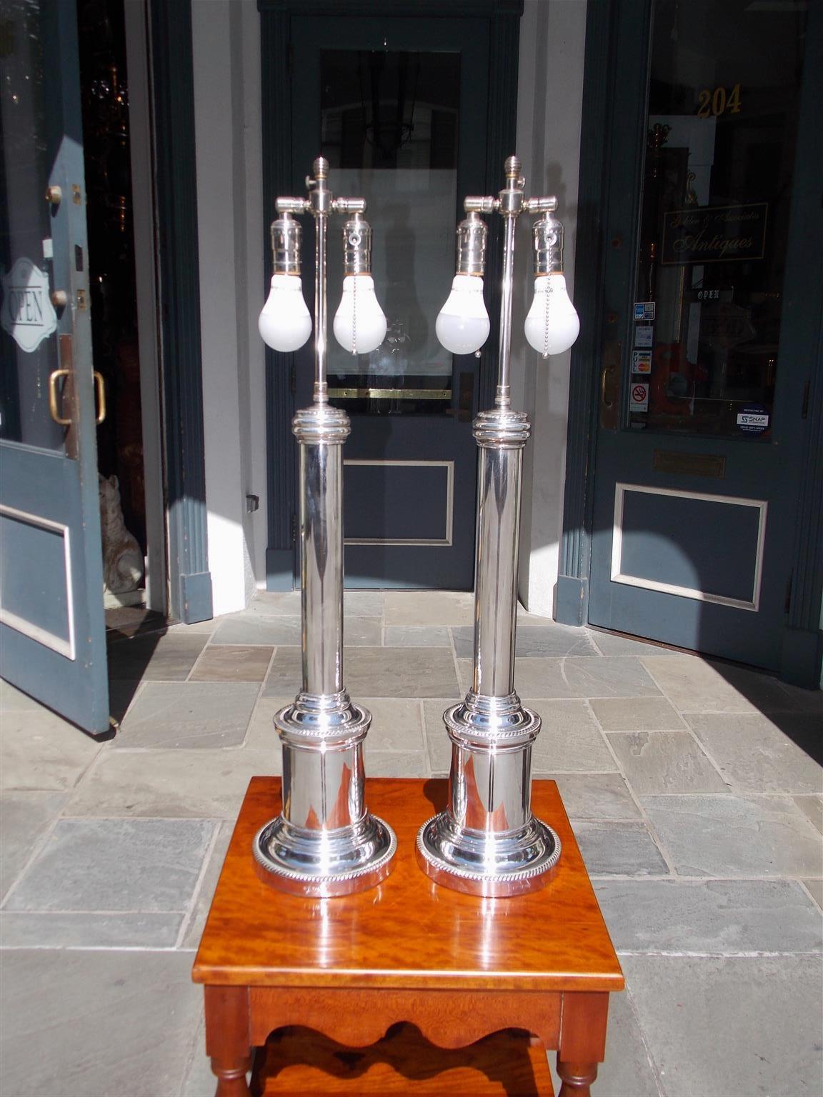 Pair of English nickel silver circular column table lamps with decorative rope motif and resting on step back circular plinth bases, Late 19th century. Stamped by maker. Lamps were originally gas and have been electrified.