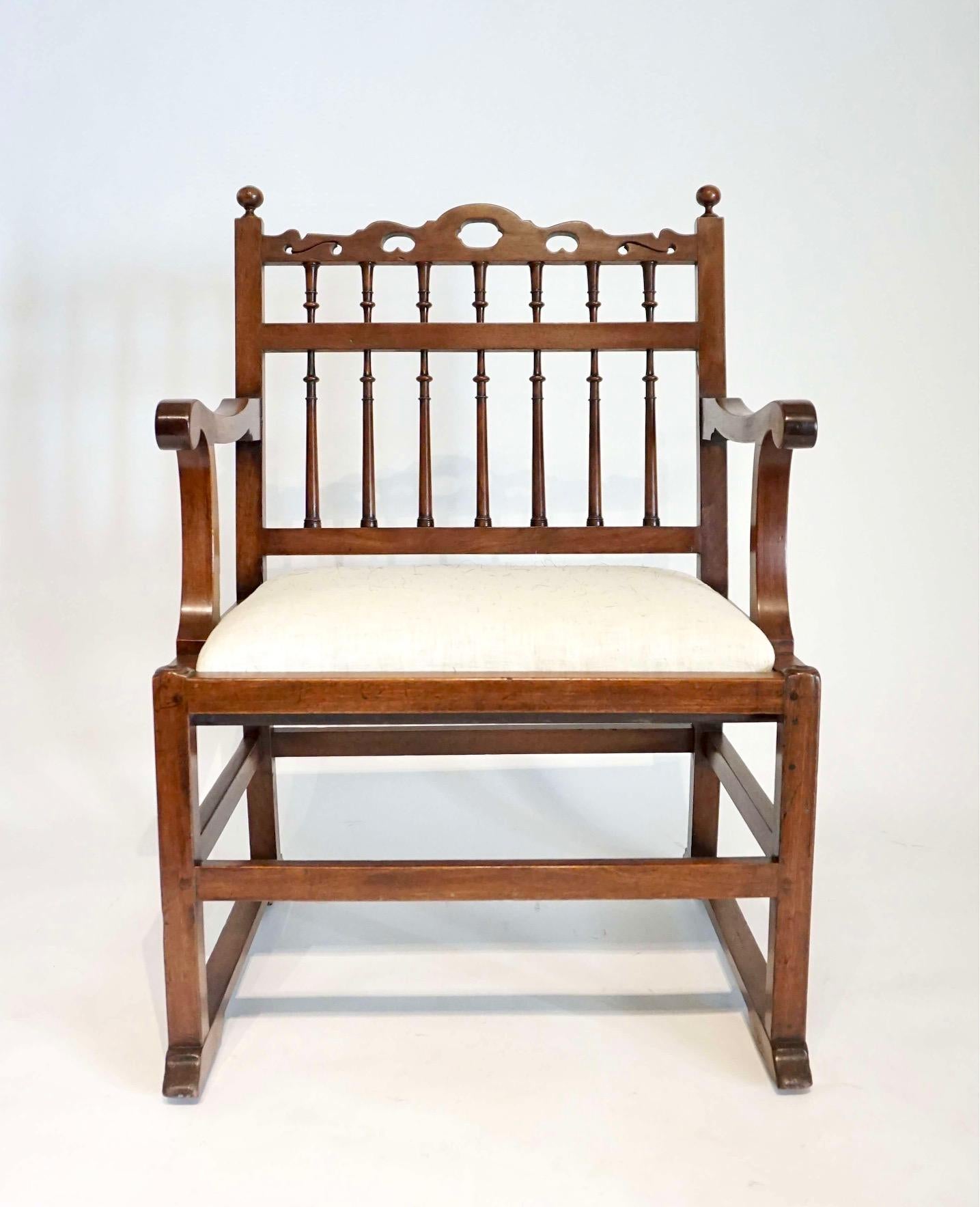 A pair of circa 1780 northern English arm chairs of solid London plane construction each with pierced top-rails above spindle backs and scrolled arm supports with drop in seats, raised on square legs joined by stretchers on sledge feet with