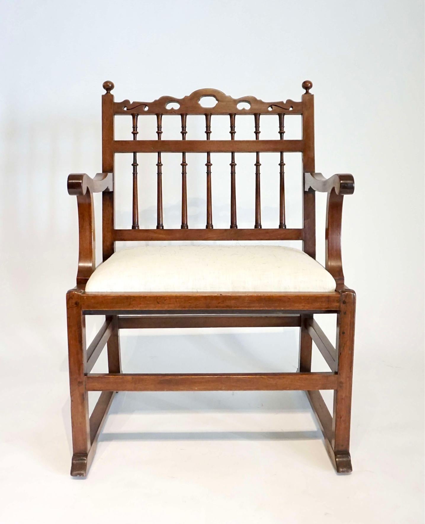A pair of circa 1780 northern English armchairs of solid London plane construction each with pierced top-rails above spindle backs and scrolled arm supports with drop in seats, raised on square legs joined by stretchers on sledge feet with concealed
