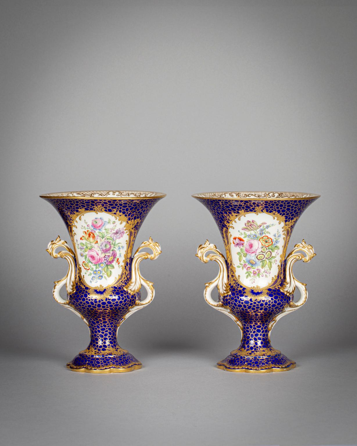 Each vase depicts a landscape scene on one side and a bouquet of flowers on the other.