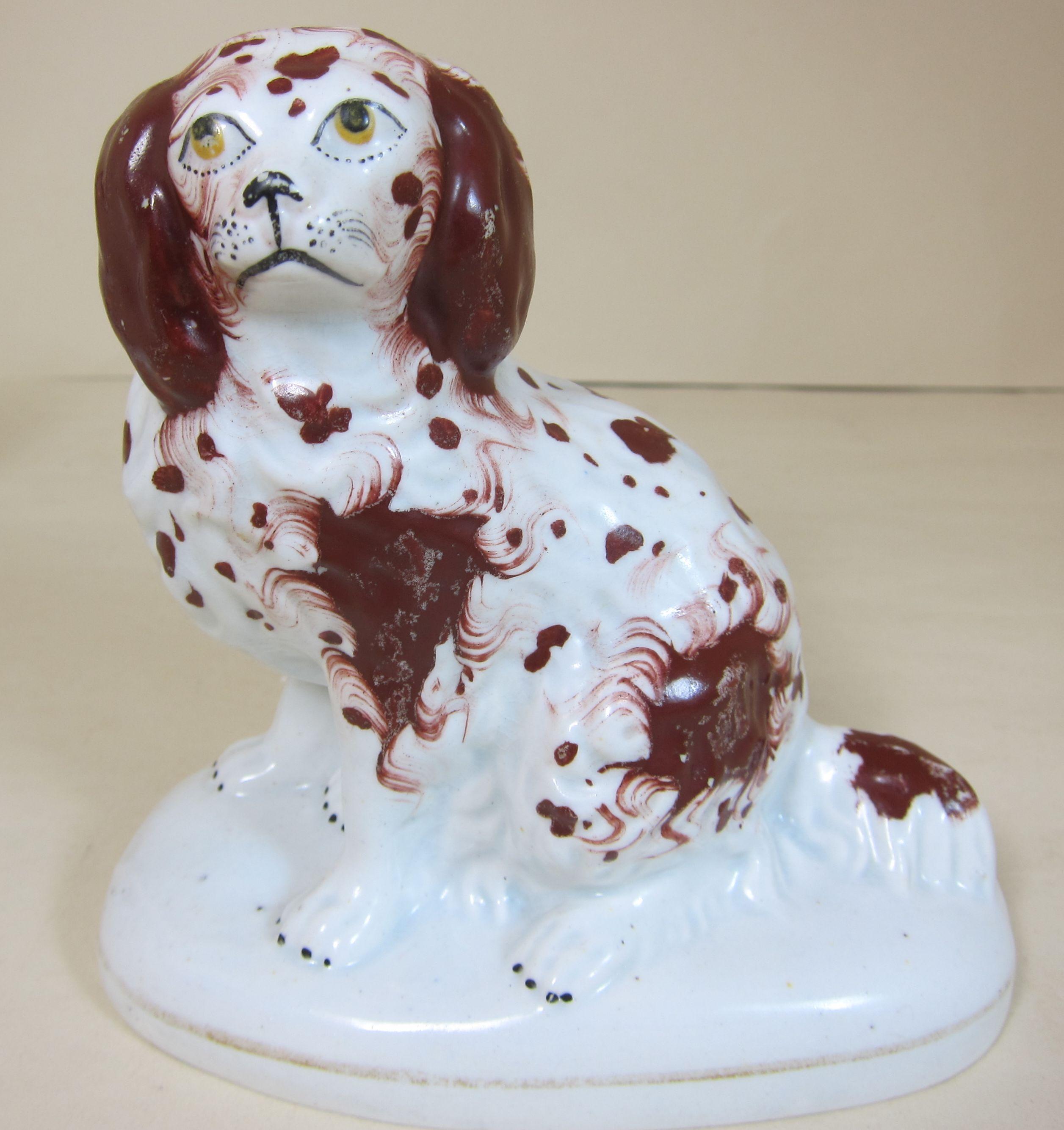 A pair of English porcelain figures of spaniels decorated in brown and burnt orange.

 