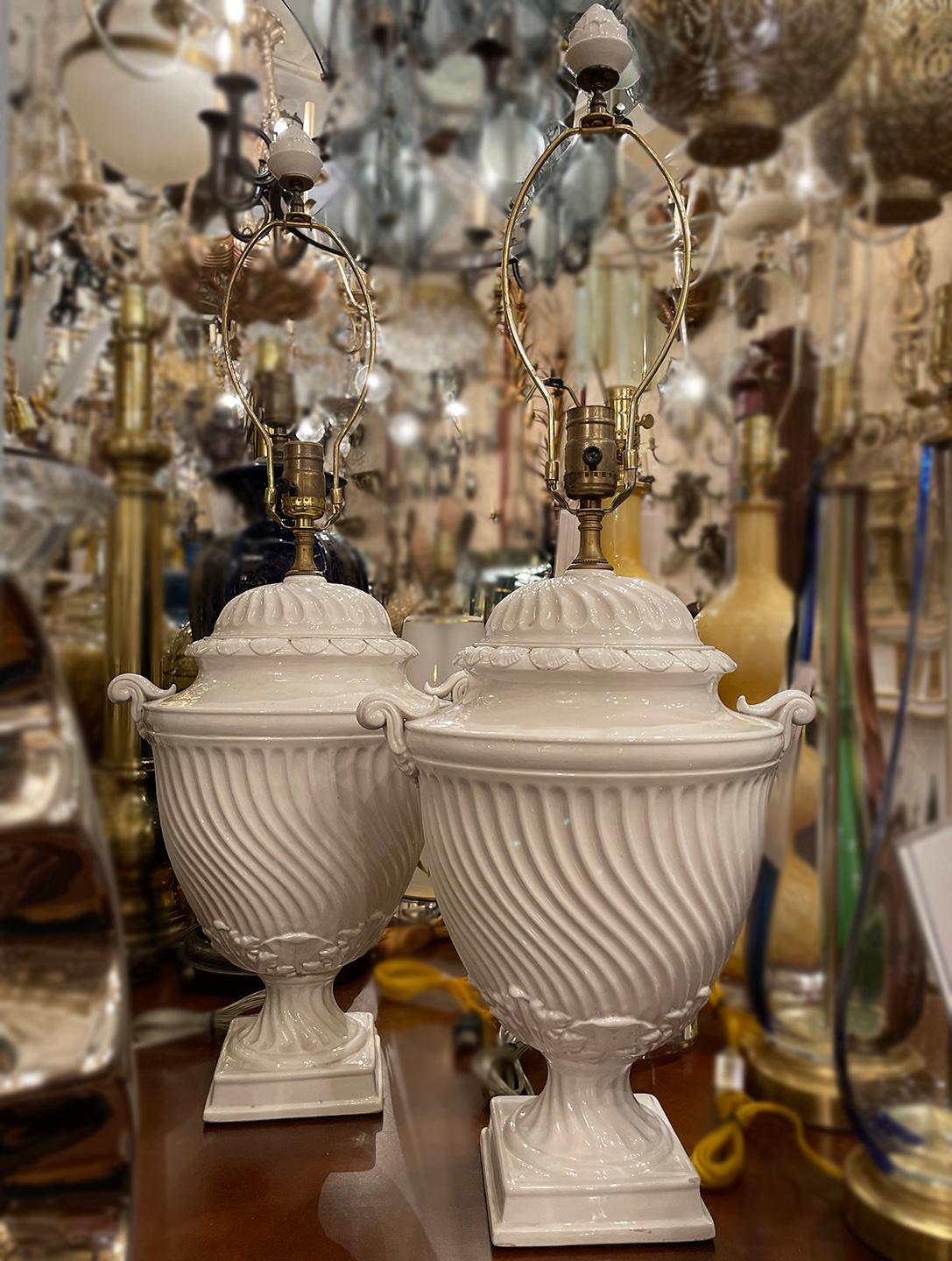 A pair of circa 1920's English porcelain table lamps of neoclassic design.

Measurements:
Height of body: 18